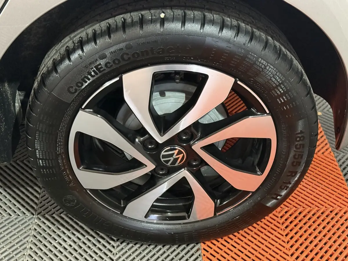 Gros plan sur la jante alliage bicolore et pneu Continental d'une Volkswagen Up gris foncé, côté avant droit.