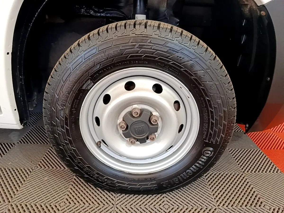 Gros plan sur la roue avant droite blanche du Fiat Ducato Fourgon 2021 avec jante acier et logo FIAT au centre.