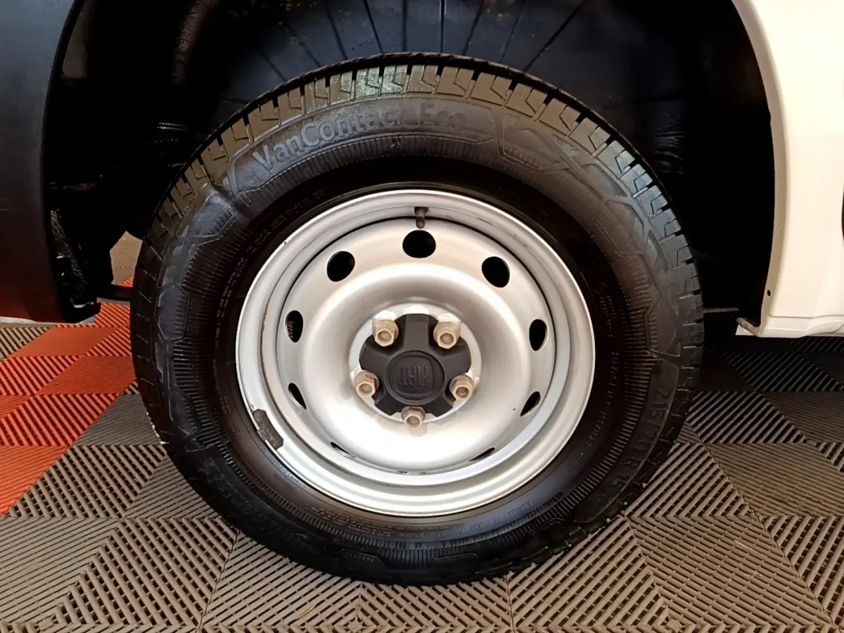 Gros plan sur la roue avant droite blanche du Fiat Ducato Fourgon 2021 avec jante acier et logo FIAT central.