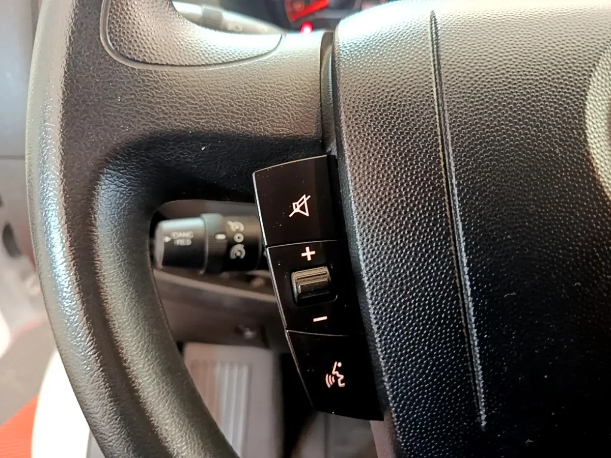 Gros plan sur le volant noir multifonctions du Fiat Ducato Fourgon blanc, montrant les commandes de volume et de son.