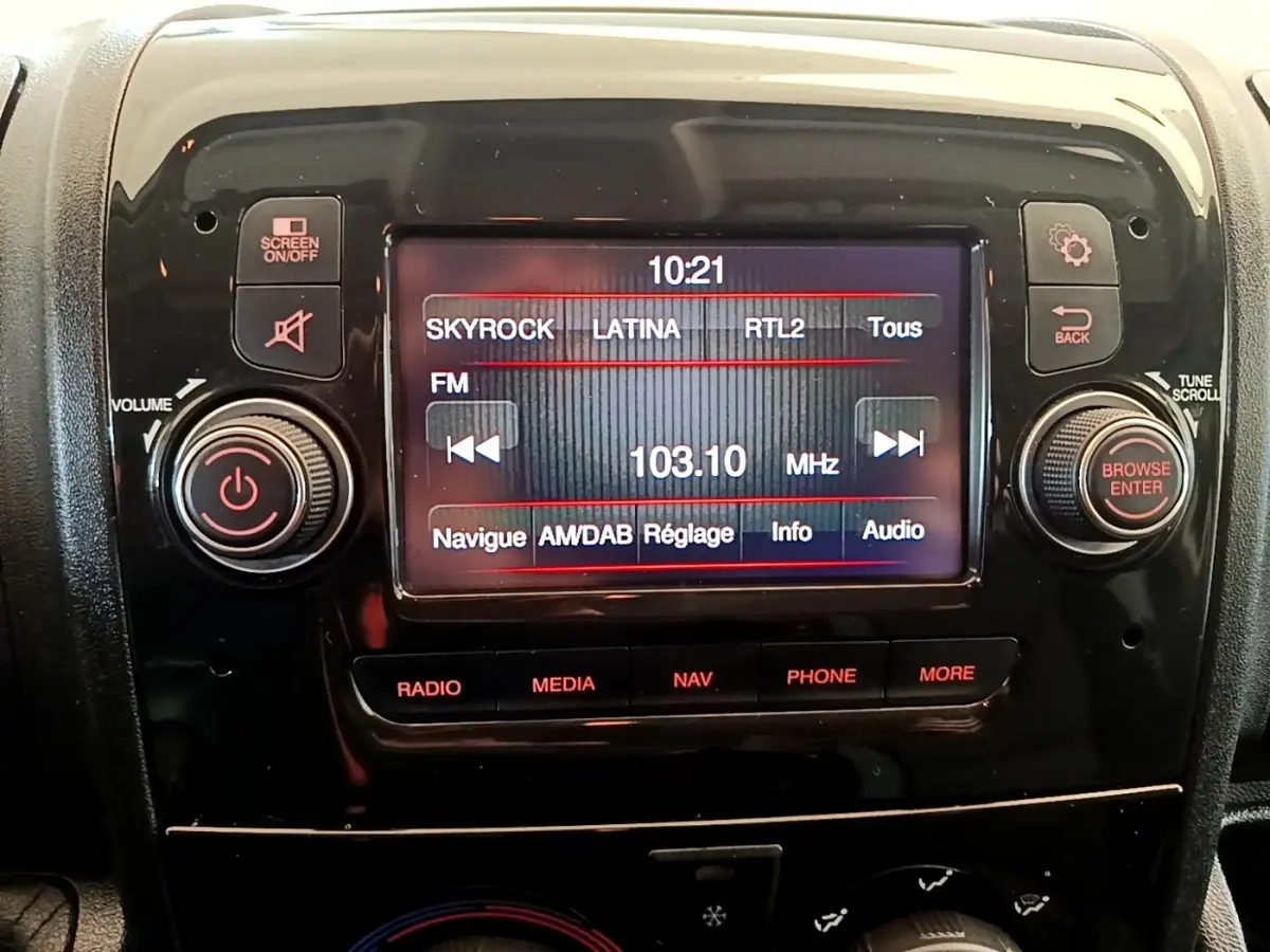 Gros plan sur l’écran tactile multimédia noir du tableau de bord du Fiat Ducato Fourgon blanc, affichant une radio FM.