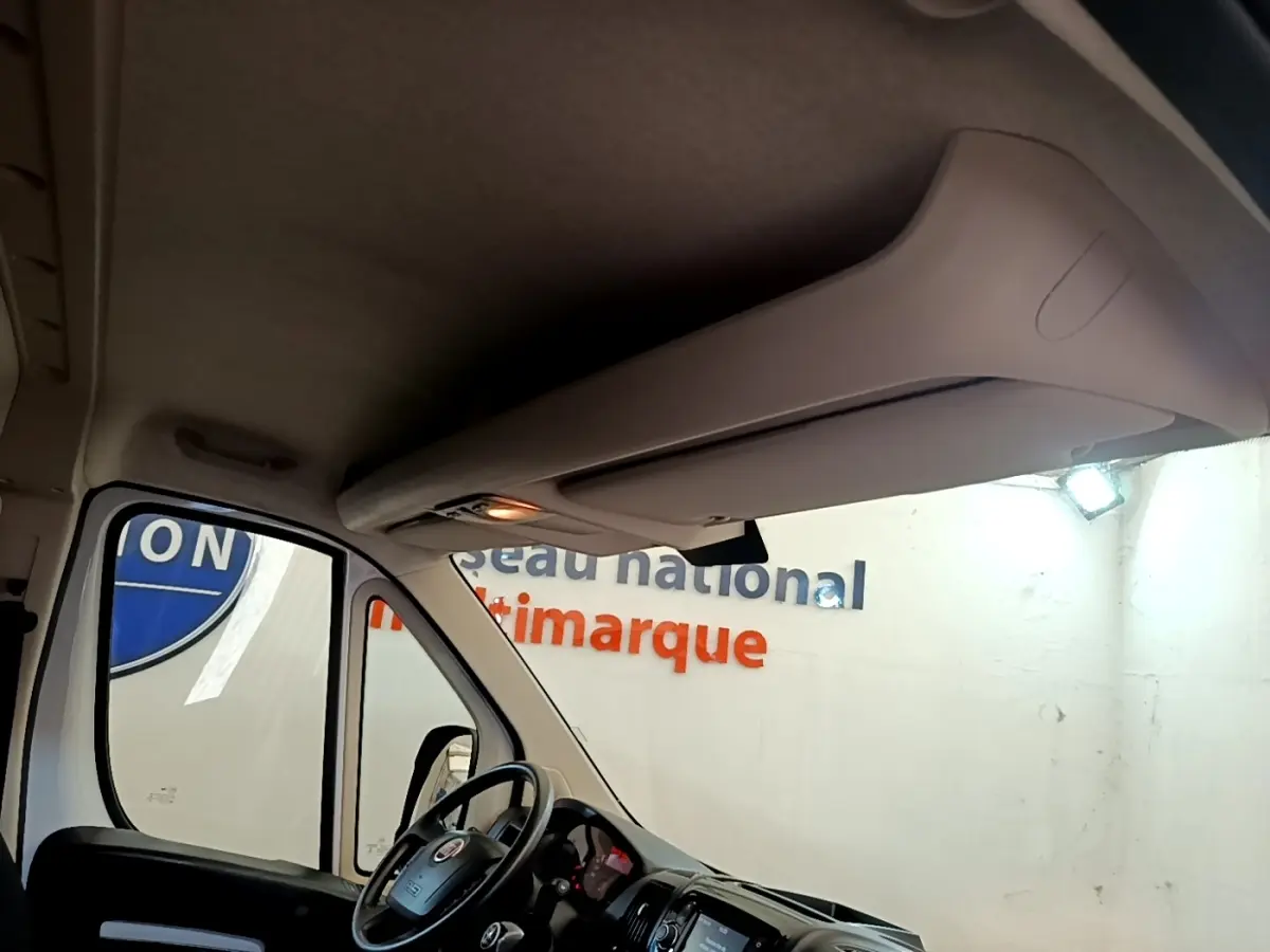 Vue intérieure du Fiat Ducato Fourgon blanc 2021, angle avant gauche, volant multifonctions et tableau de bord tactile visibles.