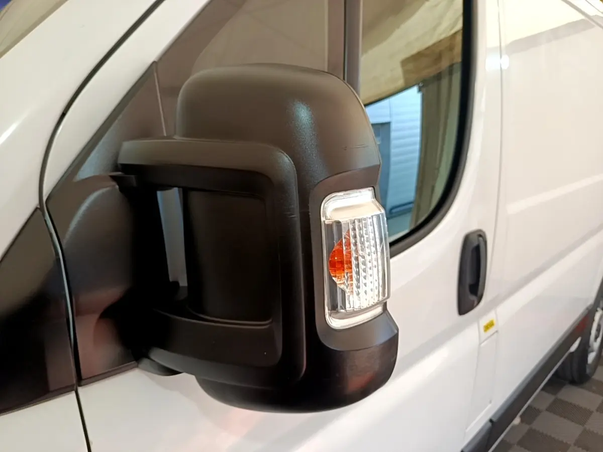 Gros plan sur le rétroviseur droit noir avec clignotant intégré du FIAT Ducato Fourgon blanc, vue latérale.