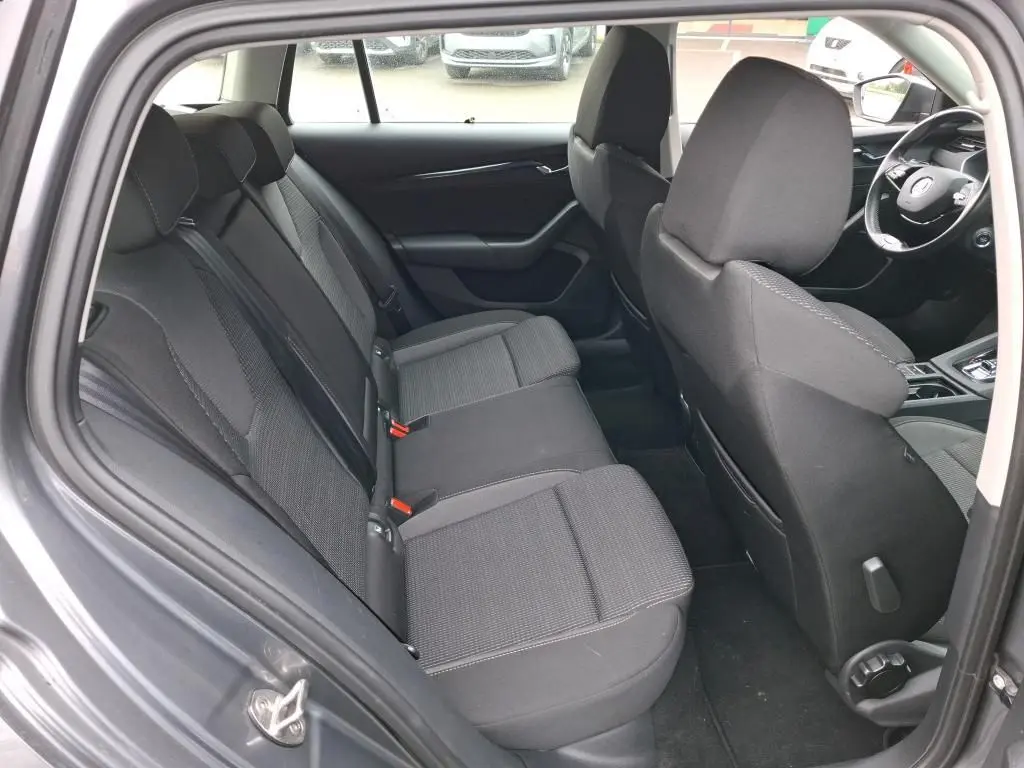 Vue intérieure côté gauche de la banquette arrière noire du Skoda Octavia Combi 2023 avec sièges tissu et appuie-têtes.