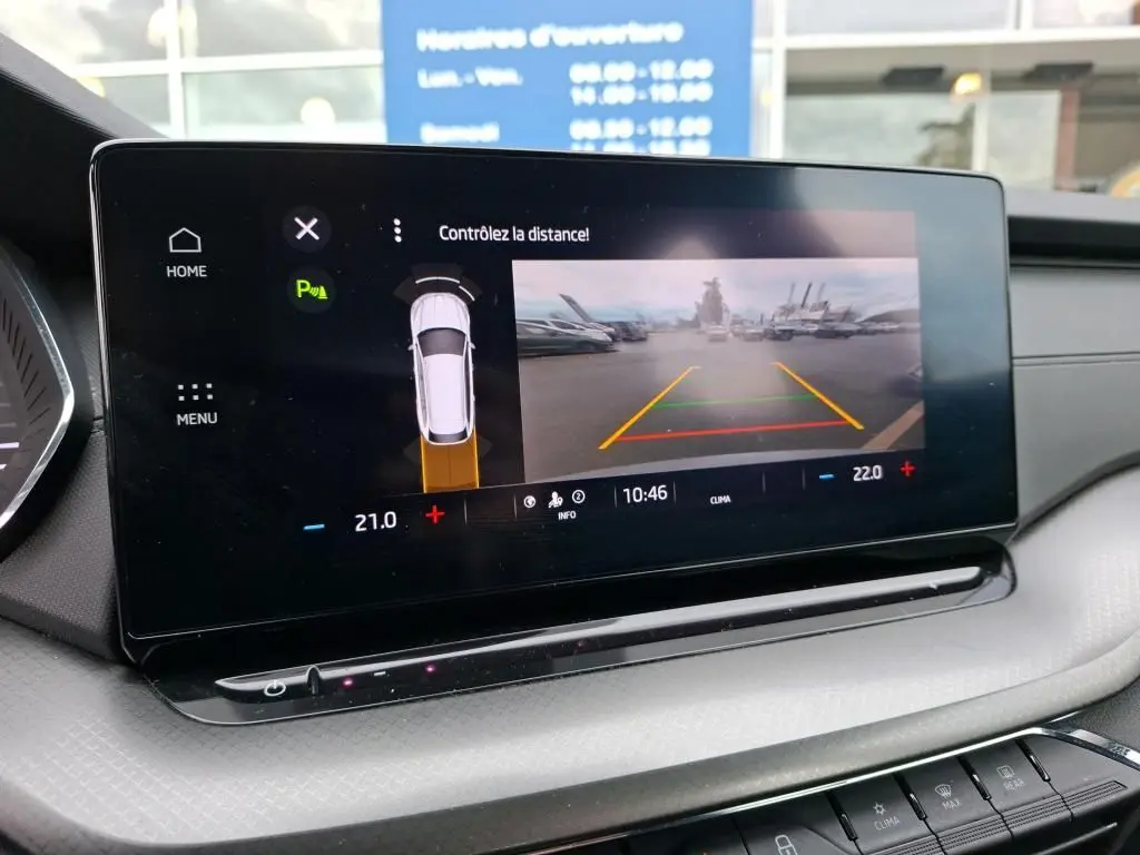 Écran tactile intérieur de la Skoda Octavia Combi gris montrant l’aide au stationnement avec caméra de recul.