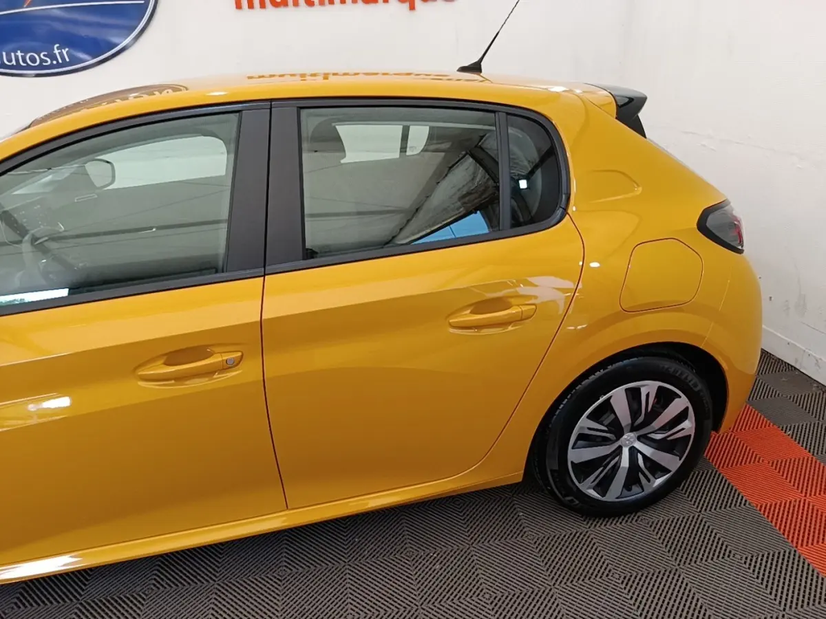 Vue latérale côté gauche d'une Peugeot 208 jaune 2023 avec jantes alliage et poignées de porte ton caisse.