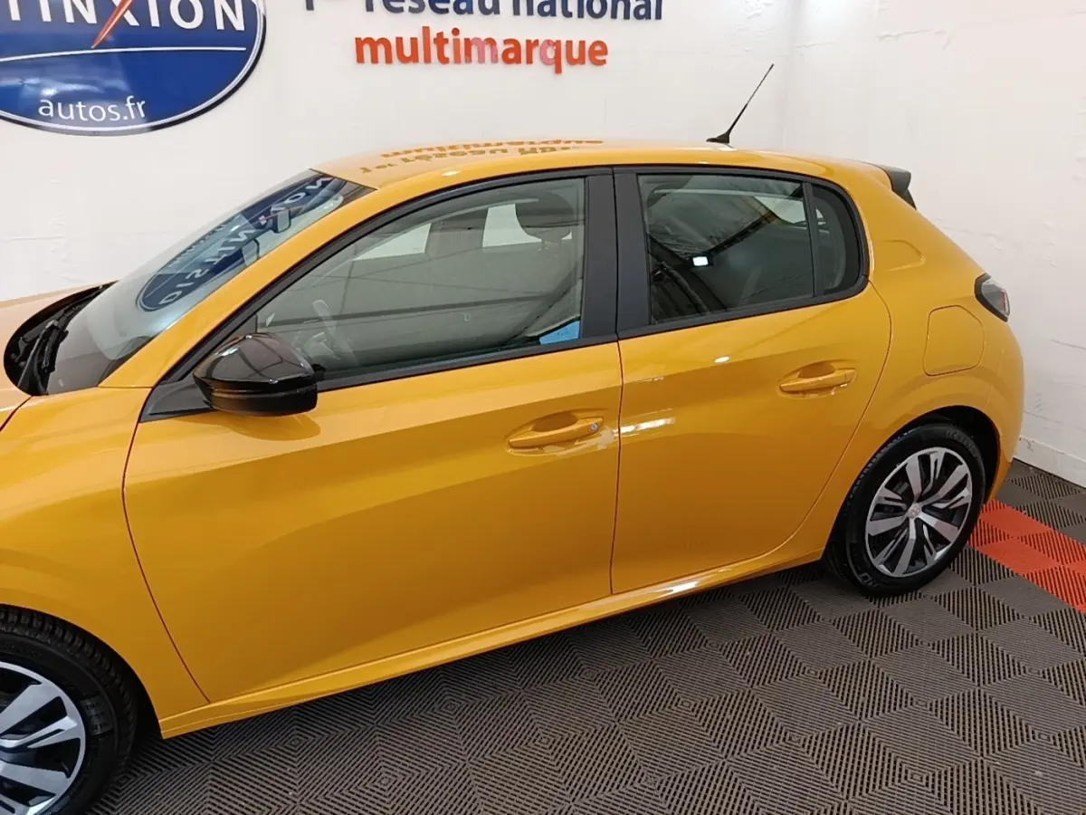Vue latérale droite d'une Peugeot 208 jaune vif avec rétroviseurs noirs et jantes stylisées en concession.