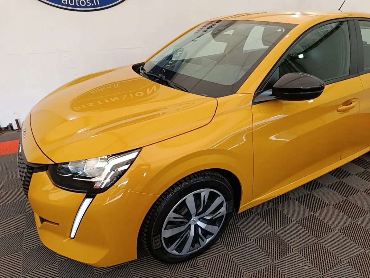 Vue 3/4 avant droite d'une Peugeot 208 jaune vif avec phares à LED et rétroviseurs noirs brillants.