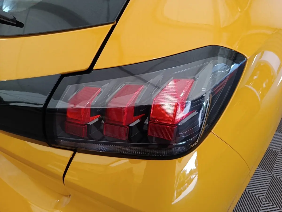 Gros plan sur le feu arrière droit rouge de la Peugeot 208 jaune PureTech 75 S&S Active Pack 2023.