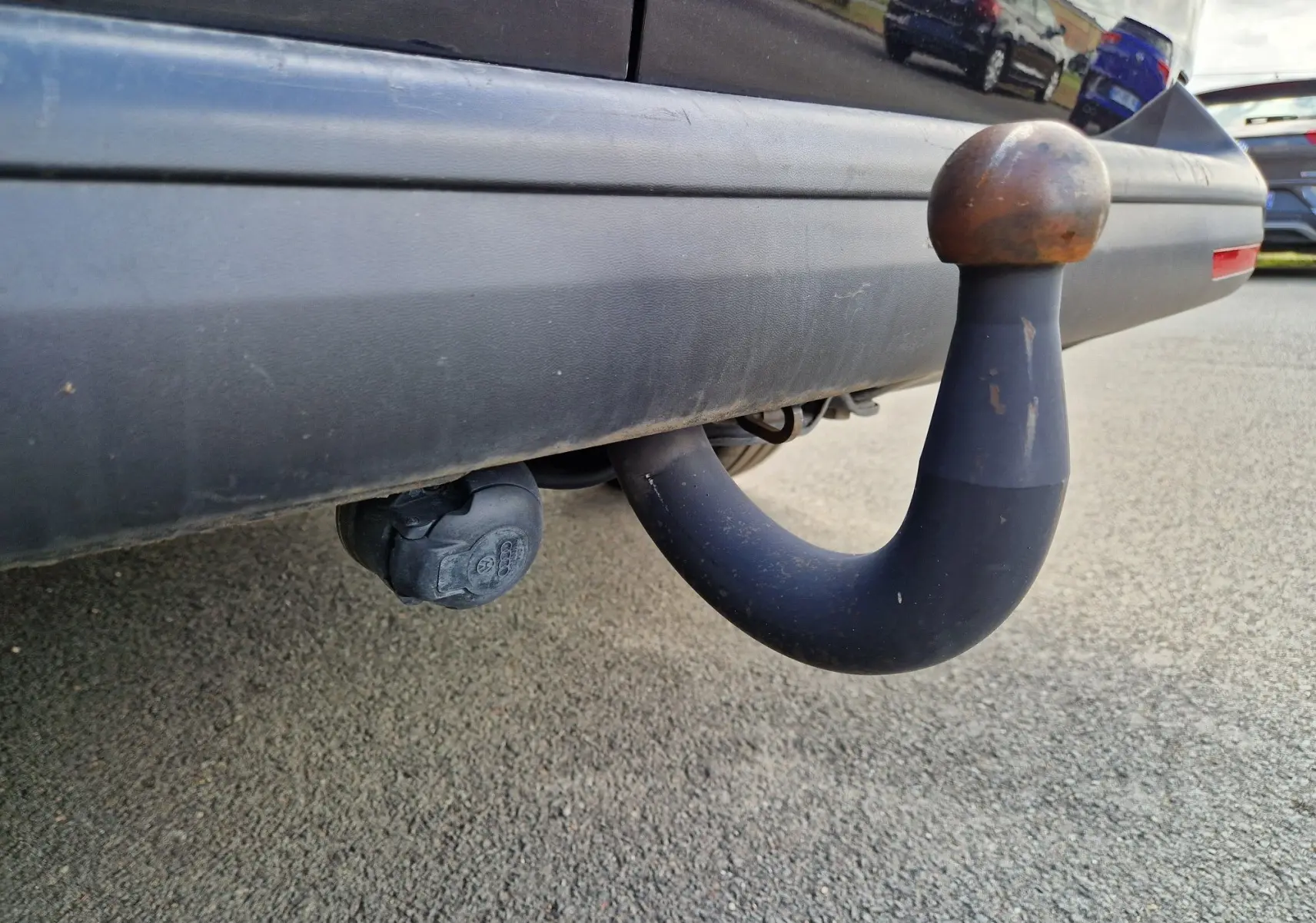 Gros plan sur le dispositif d'attelage rigide noir sous le pare-chocs arrière d'un Volkswagen Transporter noir.