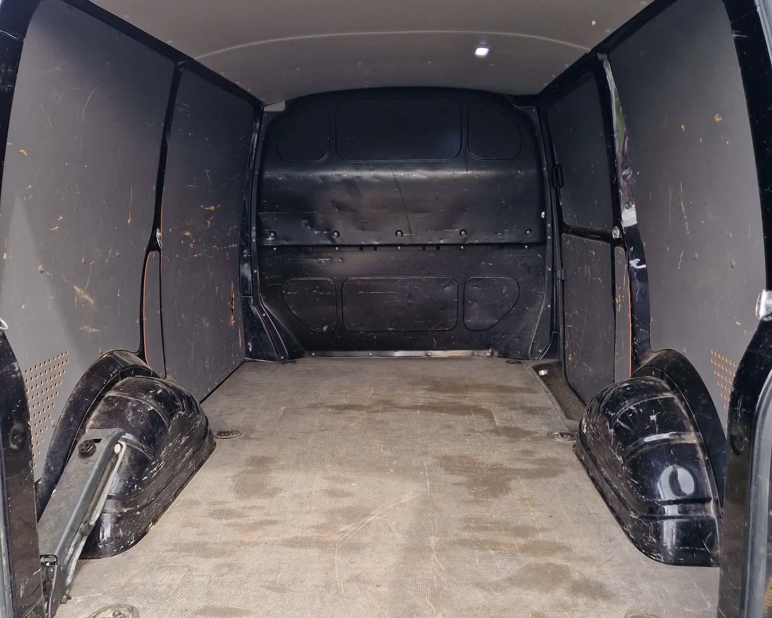 Vue intérieure arrière du coffre spacieux et noir du Volkswagen Transporter 2.0 TDi 150 ch L1H1 Business Line 2020.