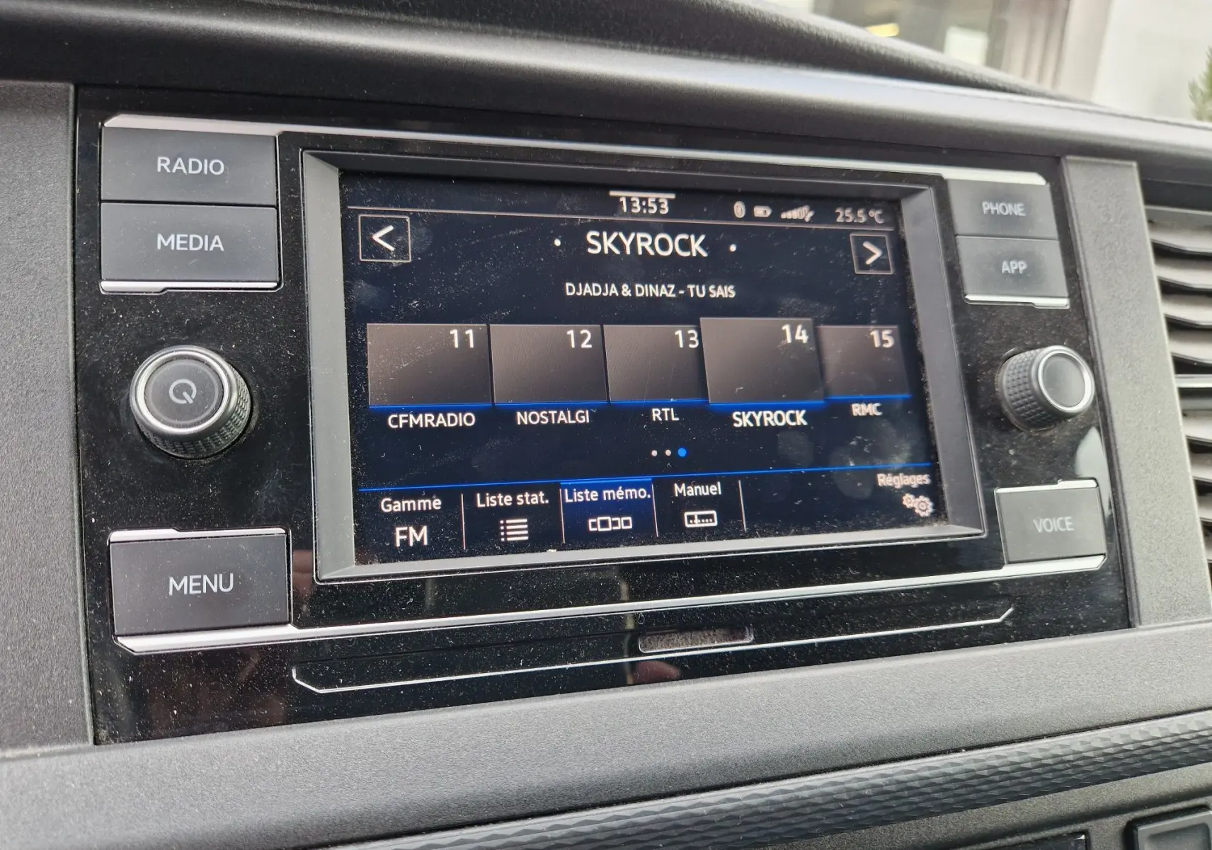 Vue rapprochée de l'écran multimédia du Volkswagen Transporter noir, affichant la radio Skyrock en FM.