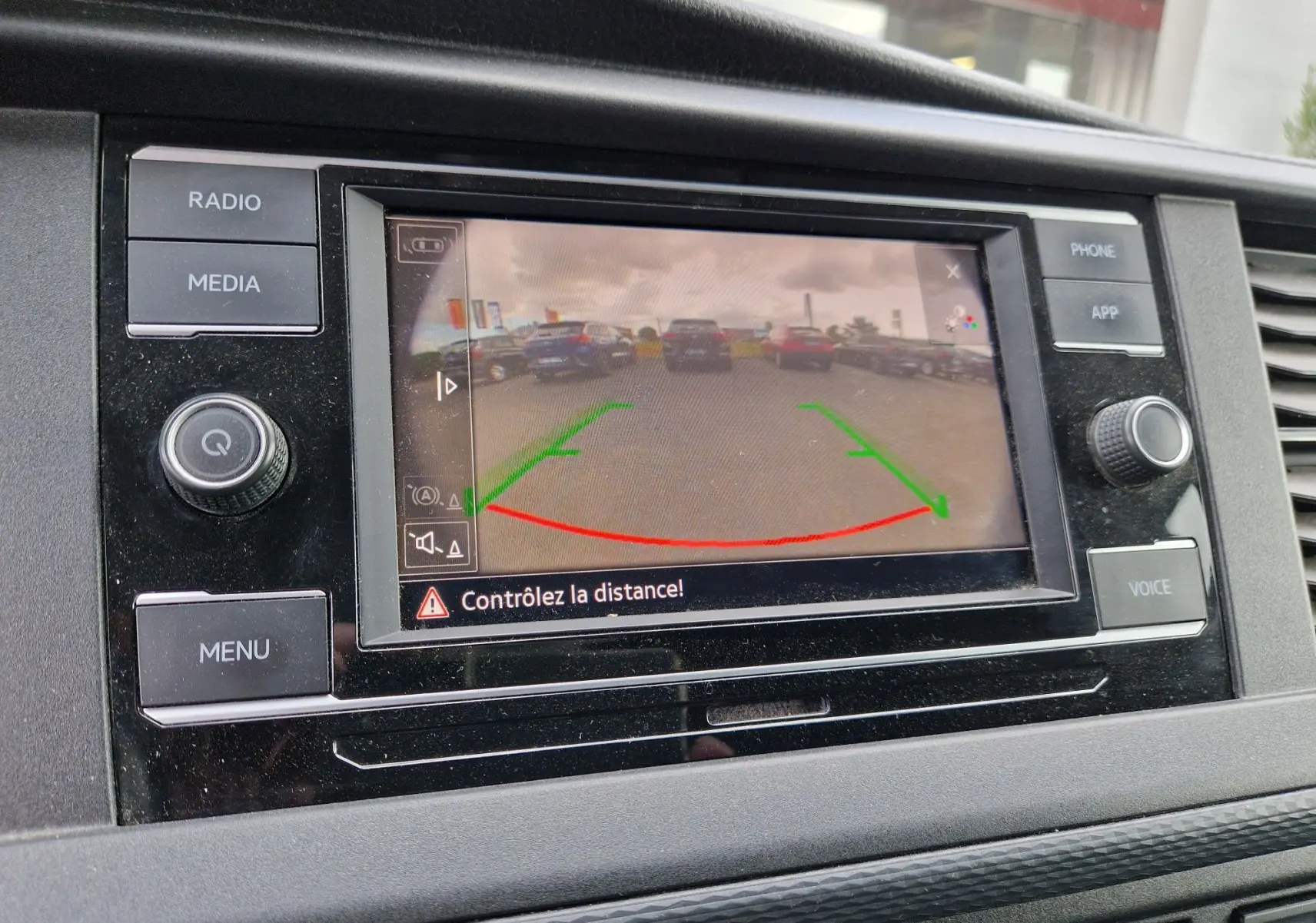 Écran de caméra de recul affichant une vue arrière du parking, intégré dans le tableau de bord noir du Volkswagen Transporter 2020.