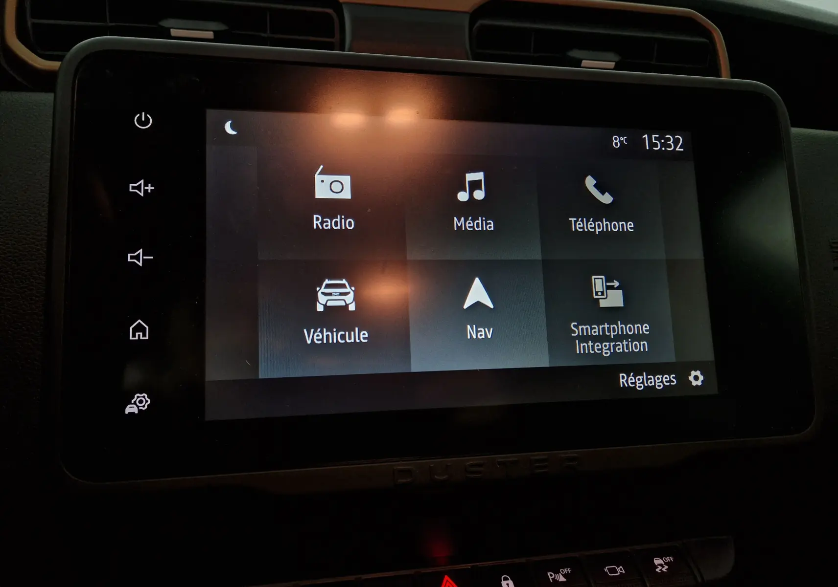 Écran tactile central du tableau de bord du Dacia Duster 2024, affichant les menus radio, média, téléphone et navigation.