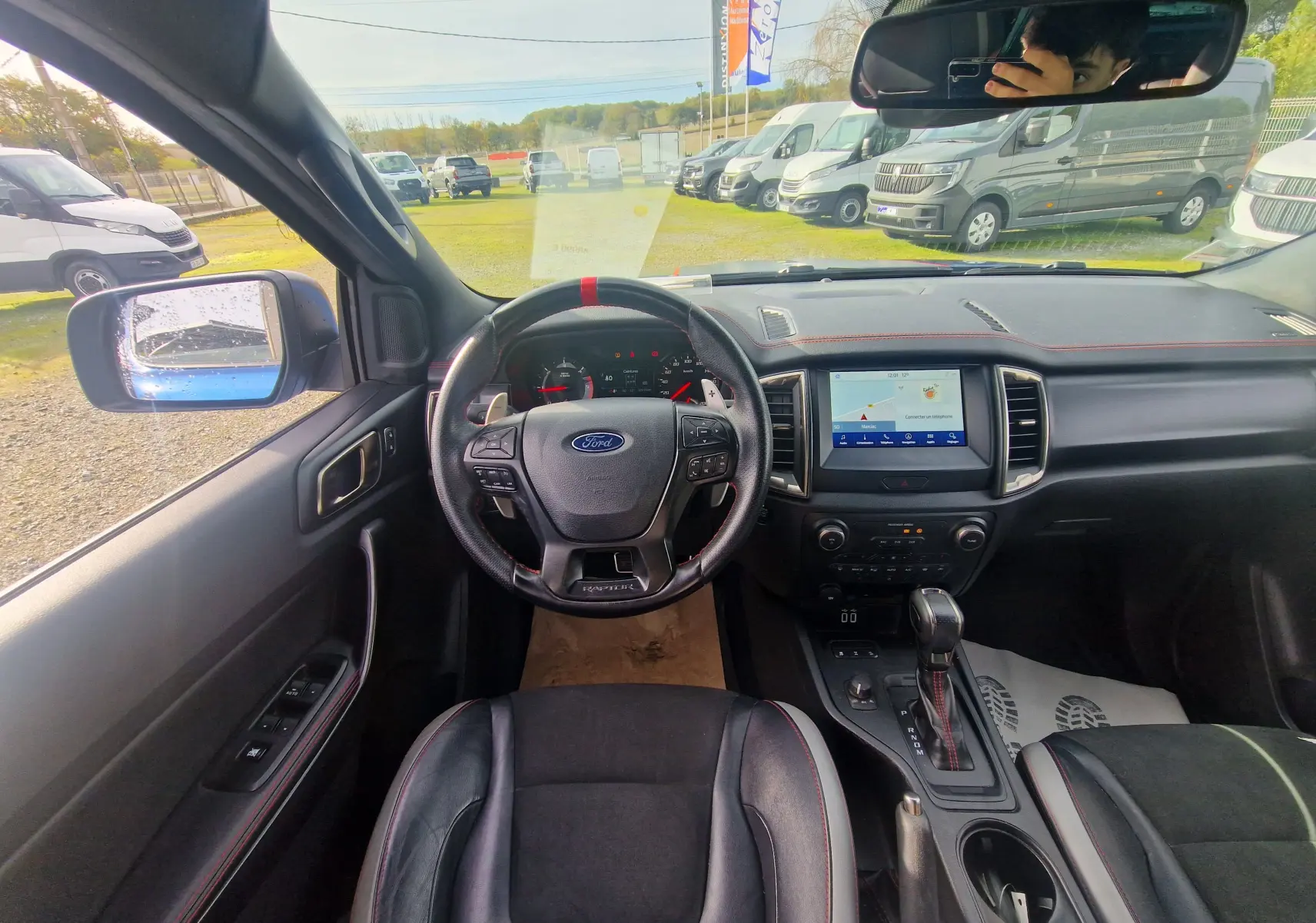 Vue intérieure du Ford Ranger Raptor 2022 montrant le volant sport avec marquage rouge et écran tactile central.