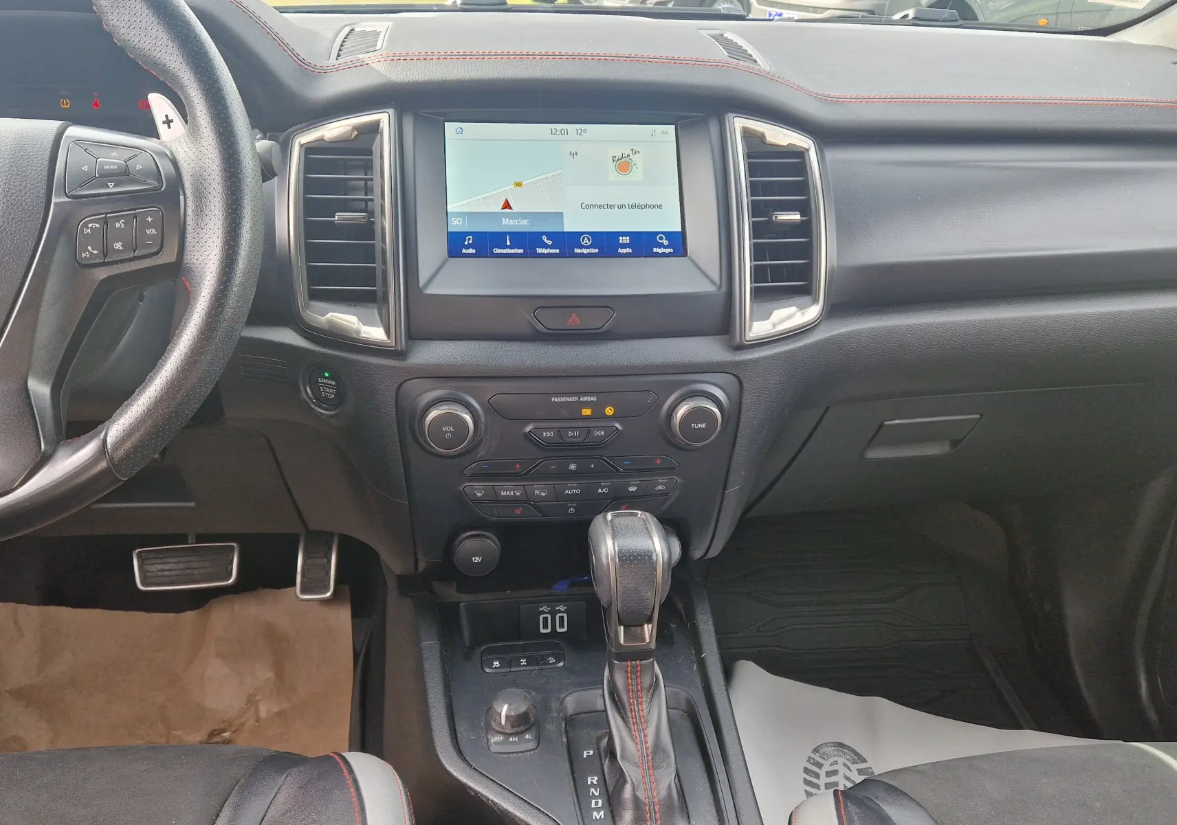 Vue intérieure du tableau de bord et console centrale du Ford Ranger Raptor 2022 avec volant cuir et écran tactile.