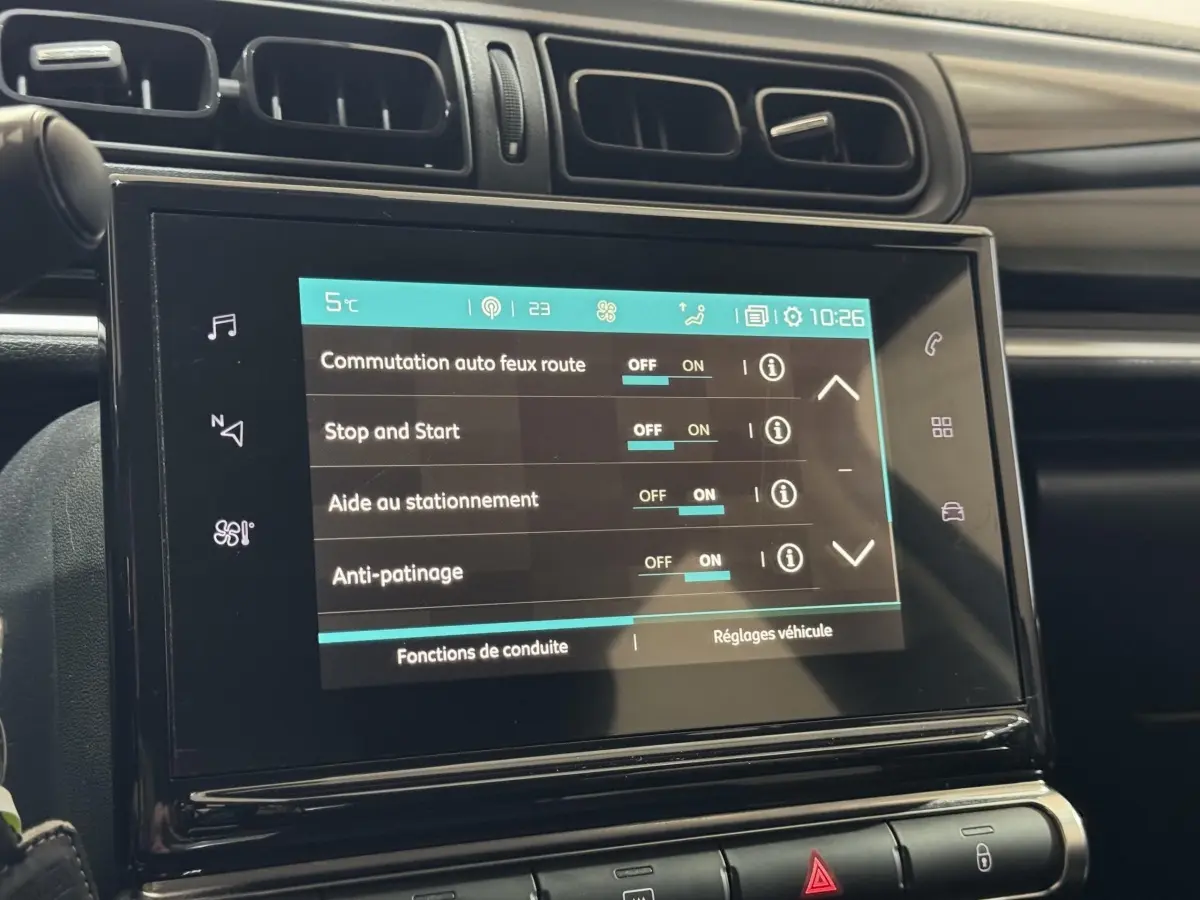 Écran tactile central affichant les réglages d'aide à la conduite dans l'habitacle d'une Citroën C3 bleu 2018.