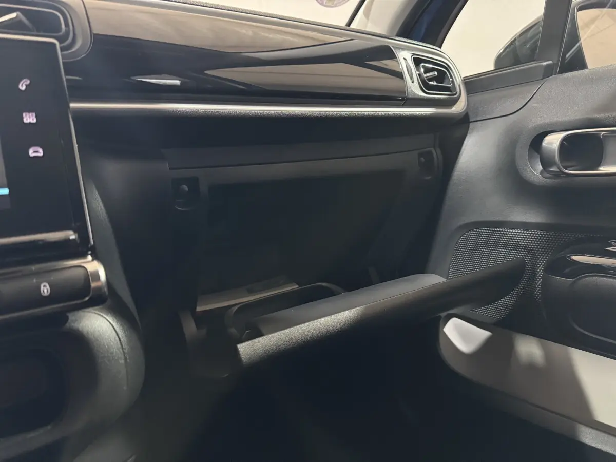 Intérieur de la Citroën C3 2018, vue du côté passager montrant la boîte à gants ouverte et la porte noire.