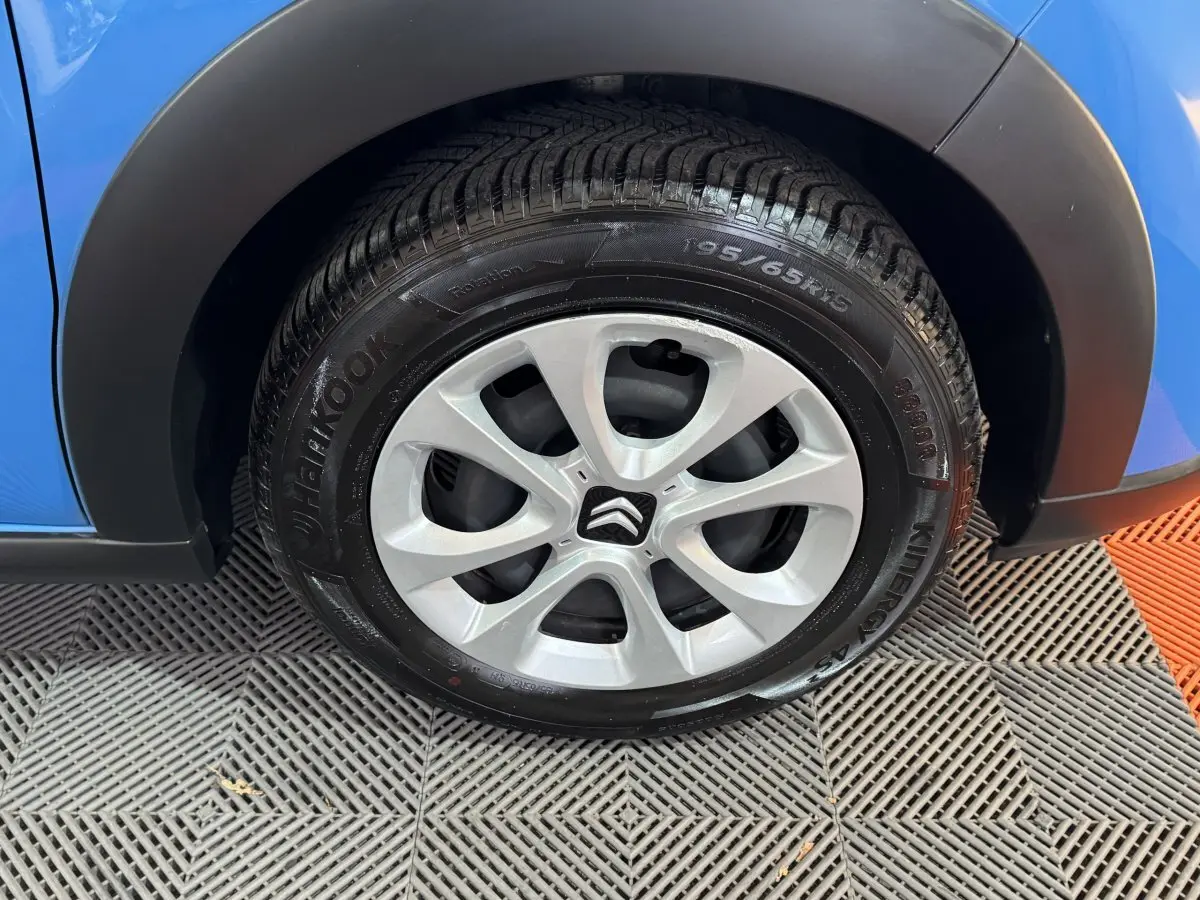 Gros plan sur la roue avant droite d'une Citroën C3 bleu 2018 avec jante argentée et pneu Hankook.