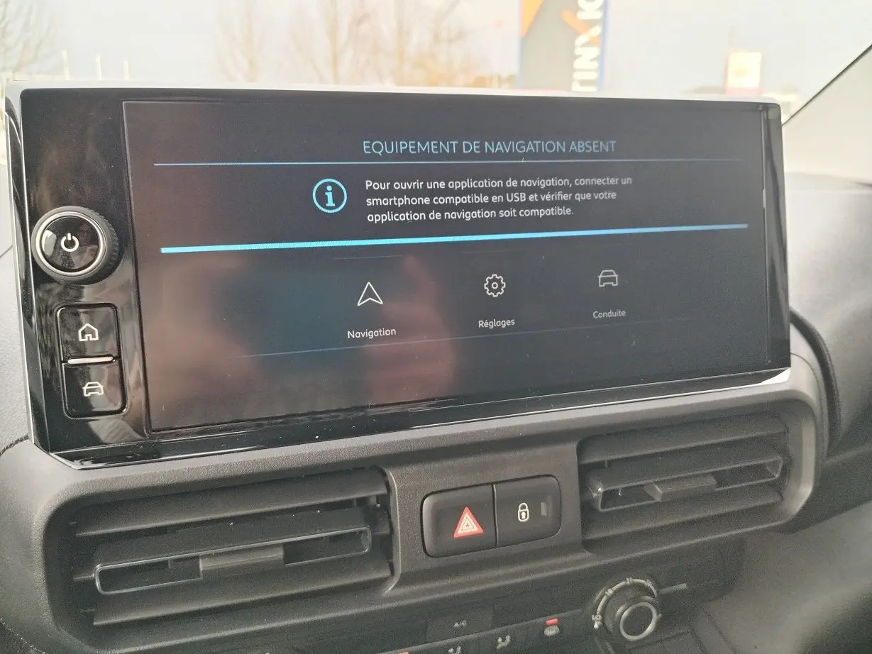 Écran central du tableau de bord du Peugeot Partner Fourgon blanc, affichant un message d'absence d'équipement de navigation.
