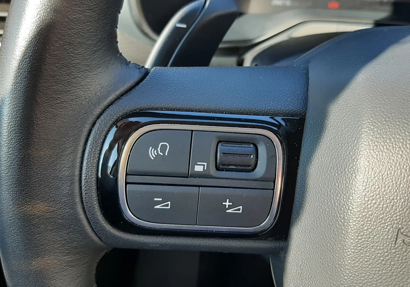 Gros plan sur les commandes multifonctions à gauche du volant du Citroën C5 Aircross 2024 noir Perla Nera.