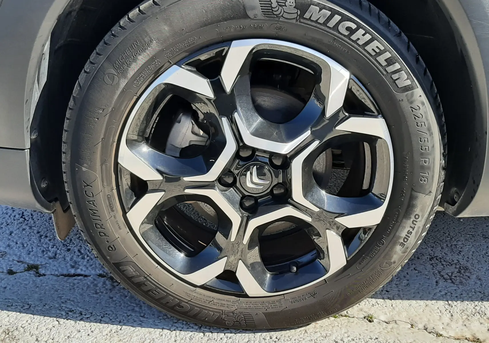 Gros plan sur la roue arrière droite d'une Citroën C5 Aircross noir Perla Nera, pneu Michelin Primacy visible.