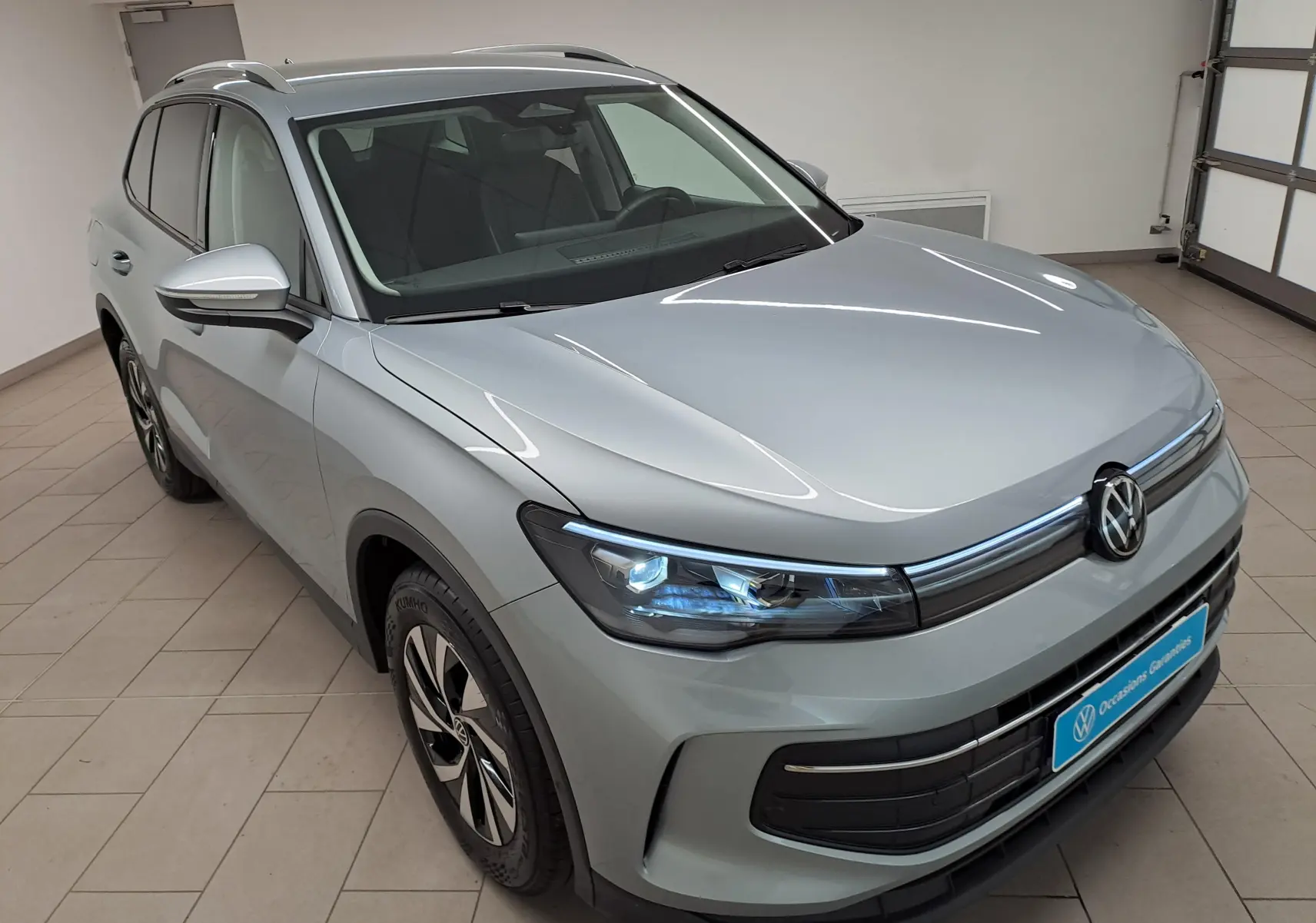 Vue 3/4 avant droit du Volkswagen Tiguan 2.0 TDI 150 DSG7 VW Edition en argent Dolomite métallisé, intérieur visible.