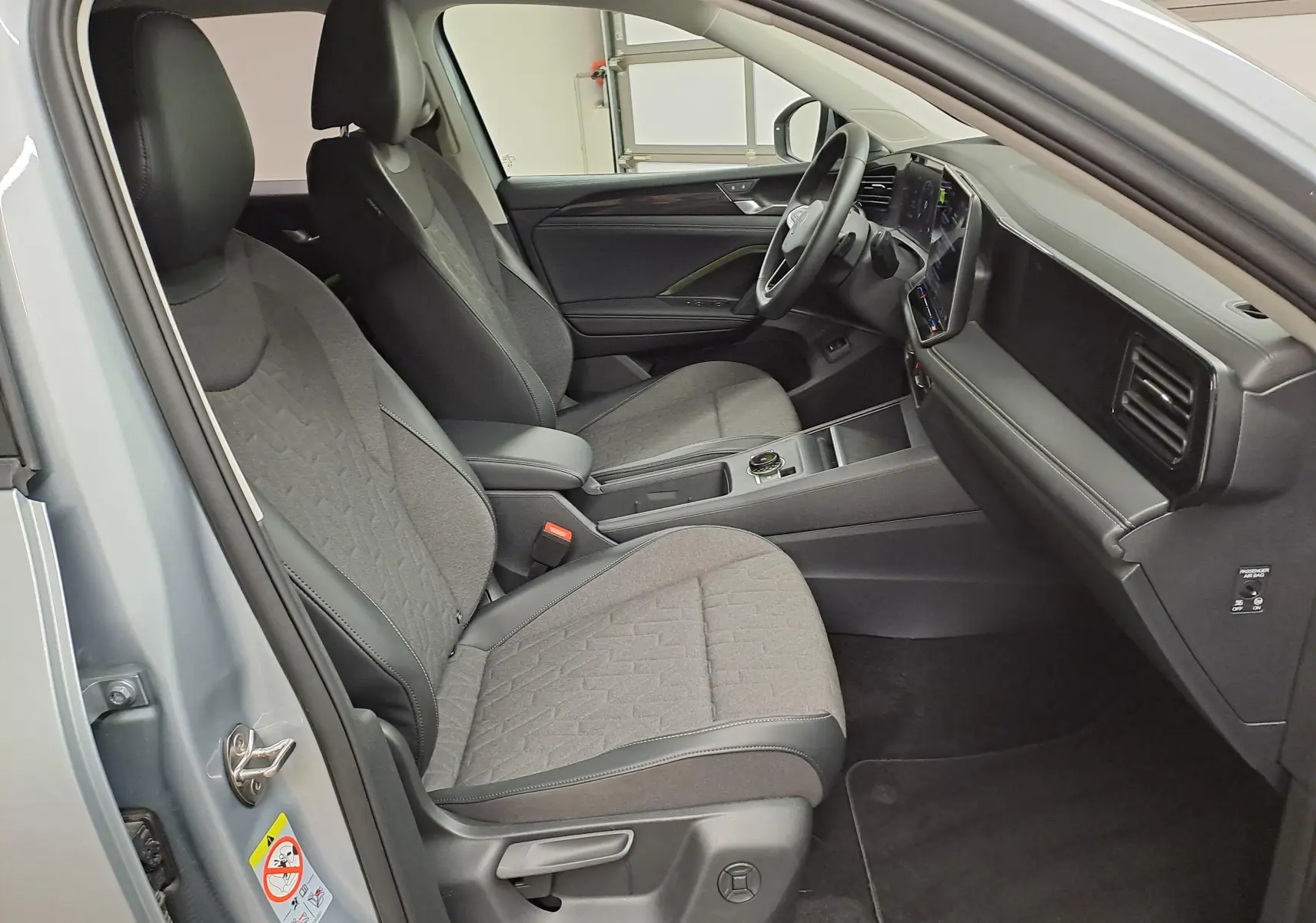 Vue intérieure côté conducteur du Volkswagen Tiguan 2025 argent Dolomite, avec sièges et volant chauffants visibles.
