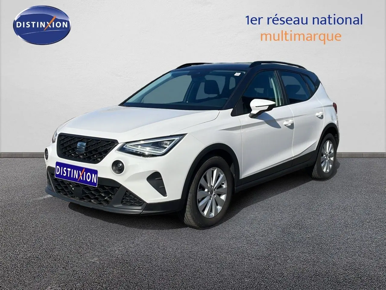 SEAT Arona blanc avec toit gris en 3/4 avant droit, mettant en valeur ses optiques LED et sa calandre noire.