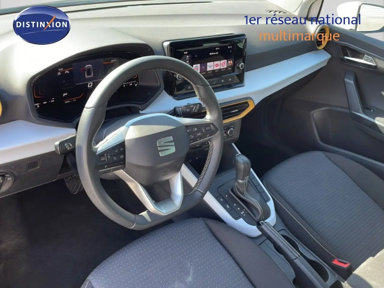 Vue intérieure côté conducteur du SEAT Arona blanc toit gris 2025, avec tableau de bord digital et volant cuir multifonction.