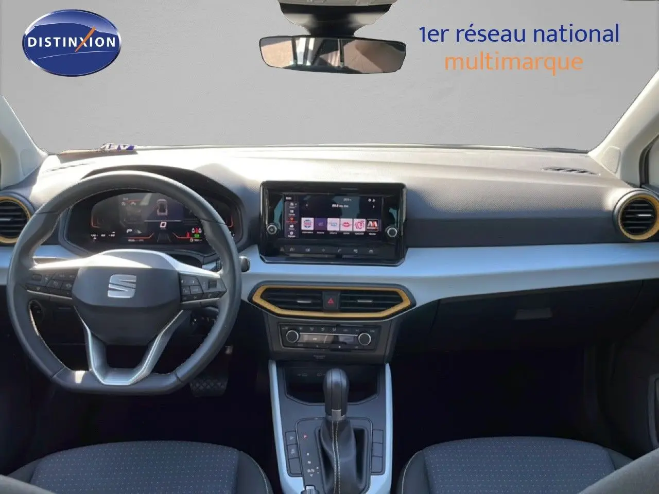 Vue intérieure avant du SEAT Arona 2025, tableau de bord noir avec écran tactile central et volant multifonction cuir.