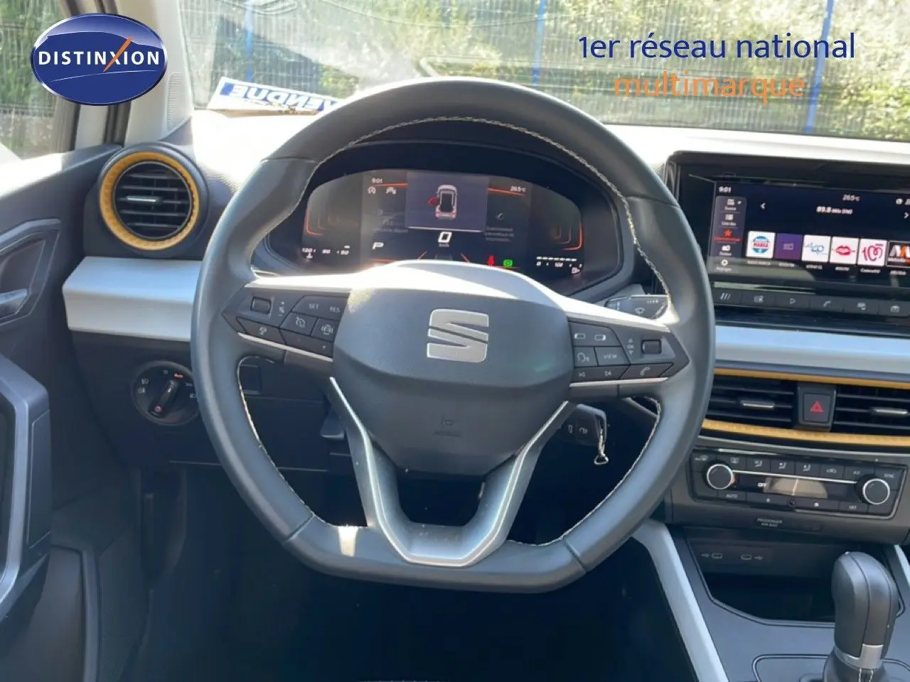 Vue intérieure centrée sur le volant cuir et tableau de bord numérique du SEAT Arona blanc toit gris 2025.