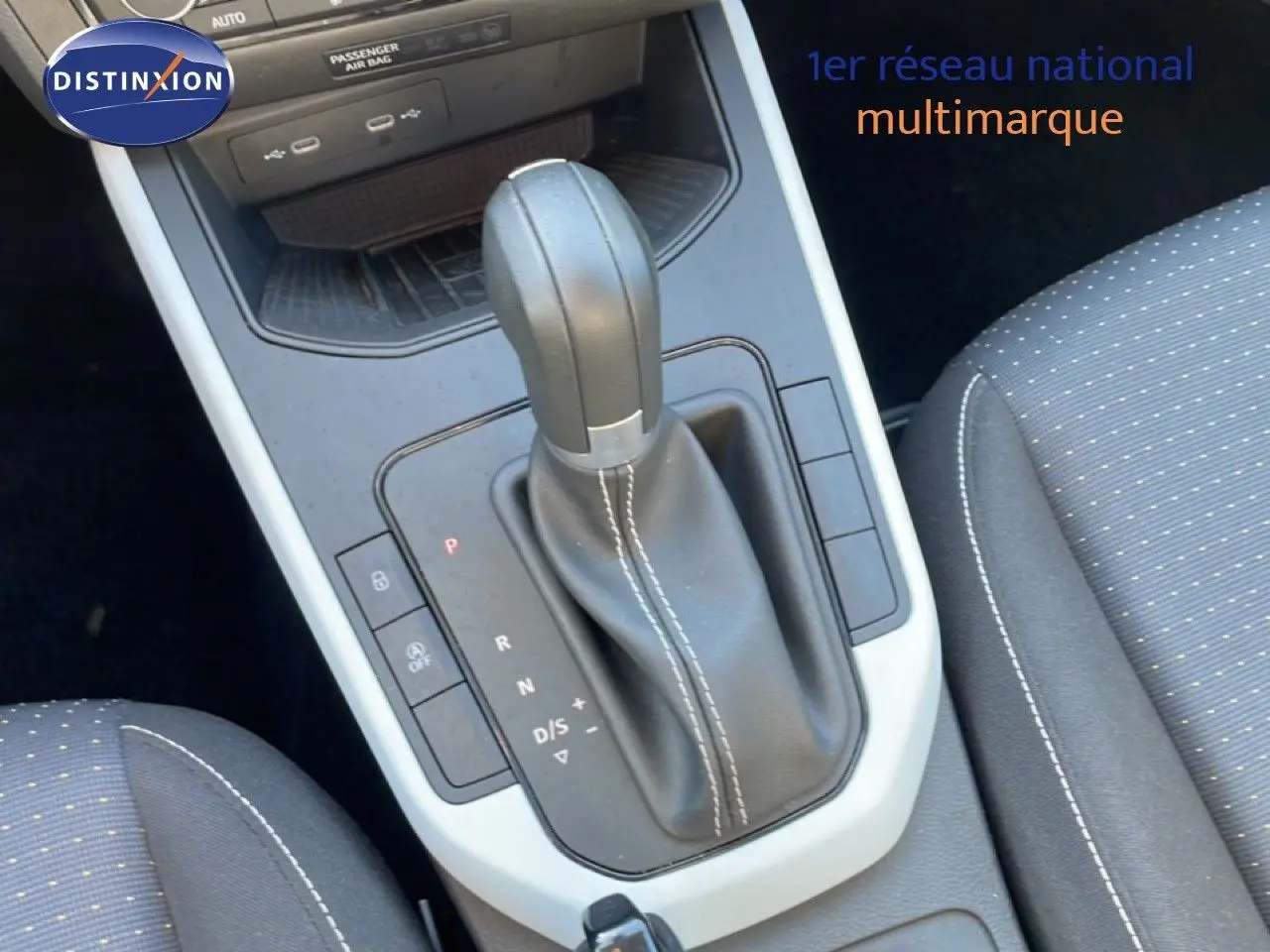 Gros plan sur la console centrale et le levier de vitesse automatique en cuir noir avec surpiqûres blanches du SEAT Arona 2025.