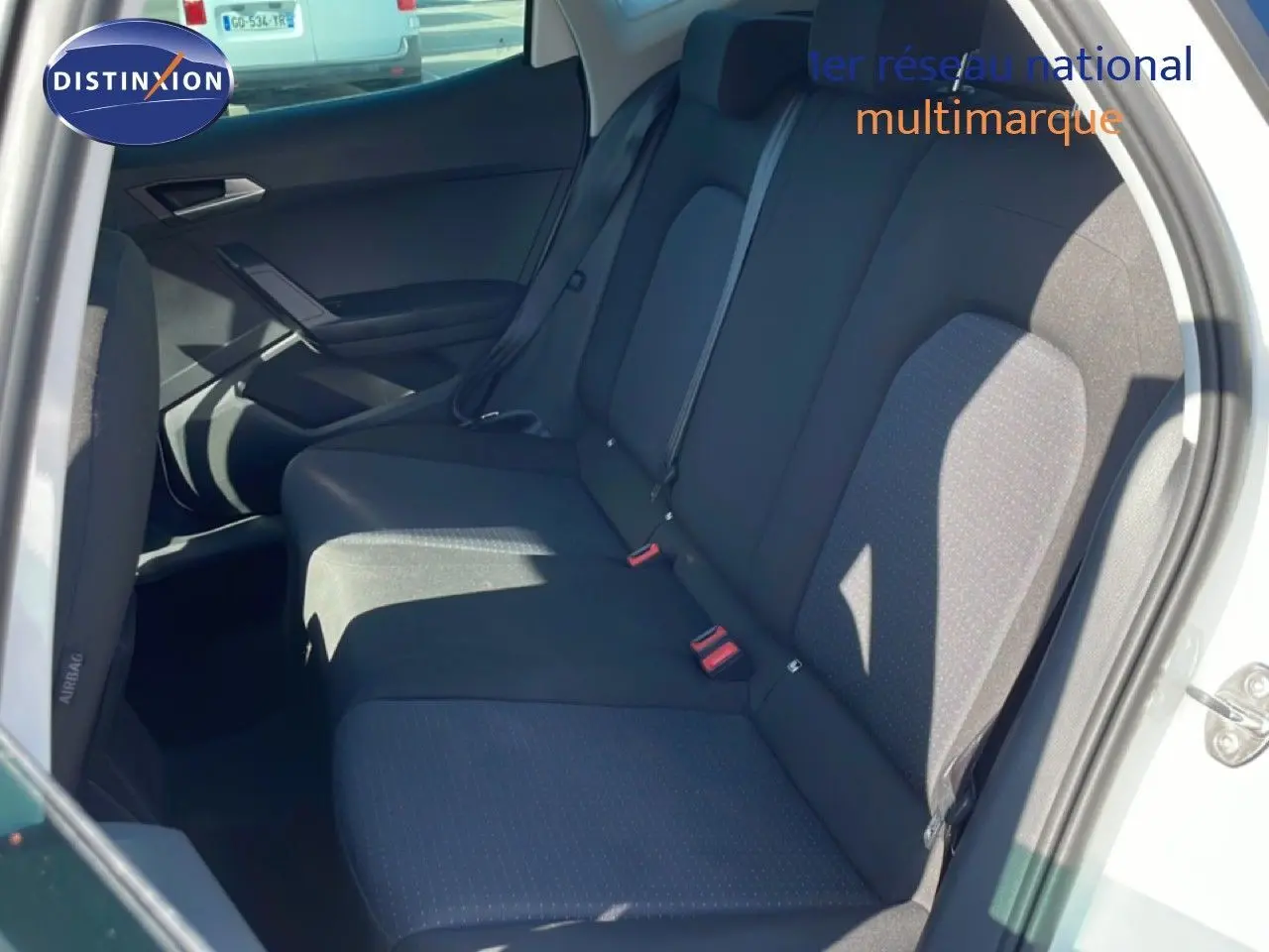 Vue intérieure côté droit montrant la banquette arrière noire du SEAT Arona blanc avec toit gris, porte ouverte.