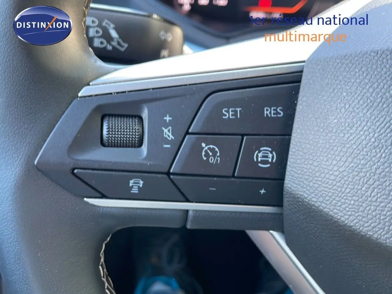 Gros plan sur les commandes au volant du SEAT Arona 2025, boutons de régulateur de vitesse et assistance à la conduite visibles.