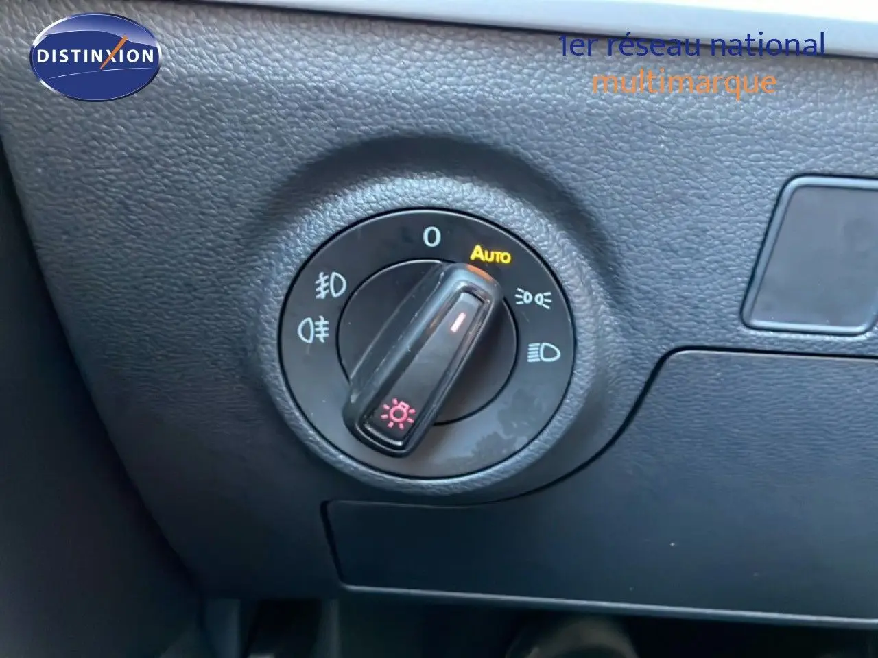Gros plan sur le bouton de commande des phares dans l’habitacle noir du SEAT Arona blanc toit gris 2025.