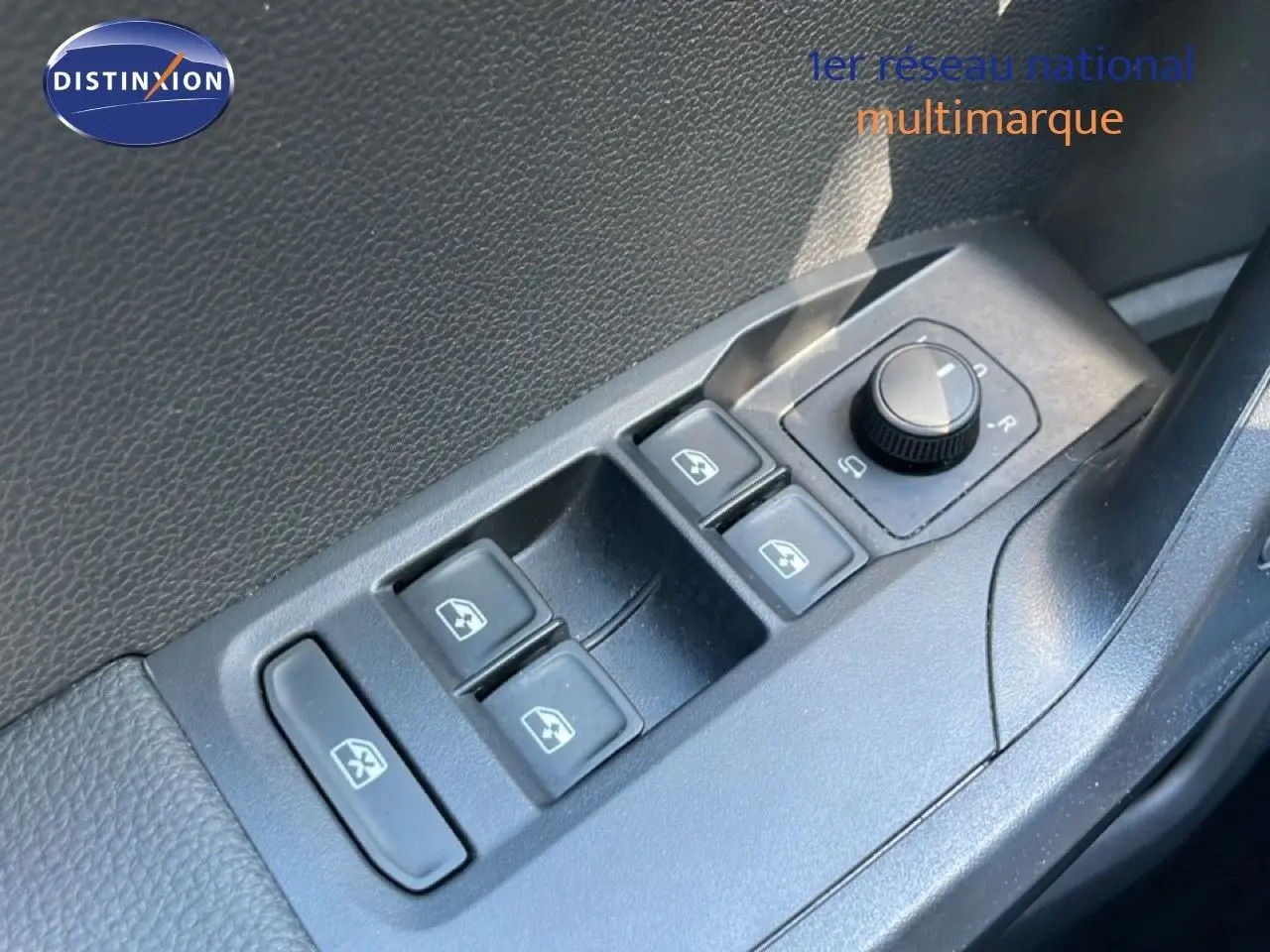 Gros plan sur les commandes des vitres électriques et du réglage des rétroviseurs côté conducteur d’un SEAT Arona 2025 intérieur noir.