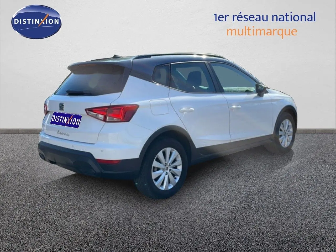 Vue 3/4 arrière droite d'un SEAT Arona blanc avec toit gris, jantes alliage et détails noirs sur les bas de caisse.