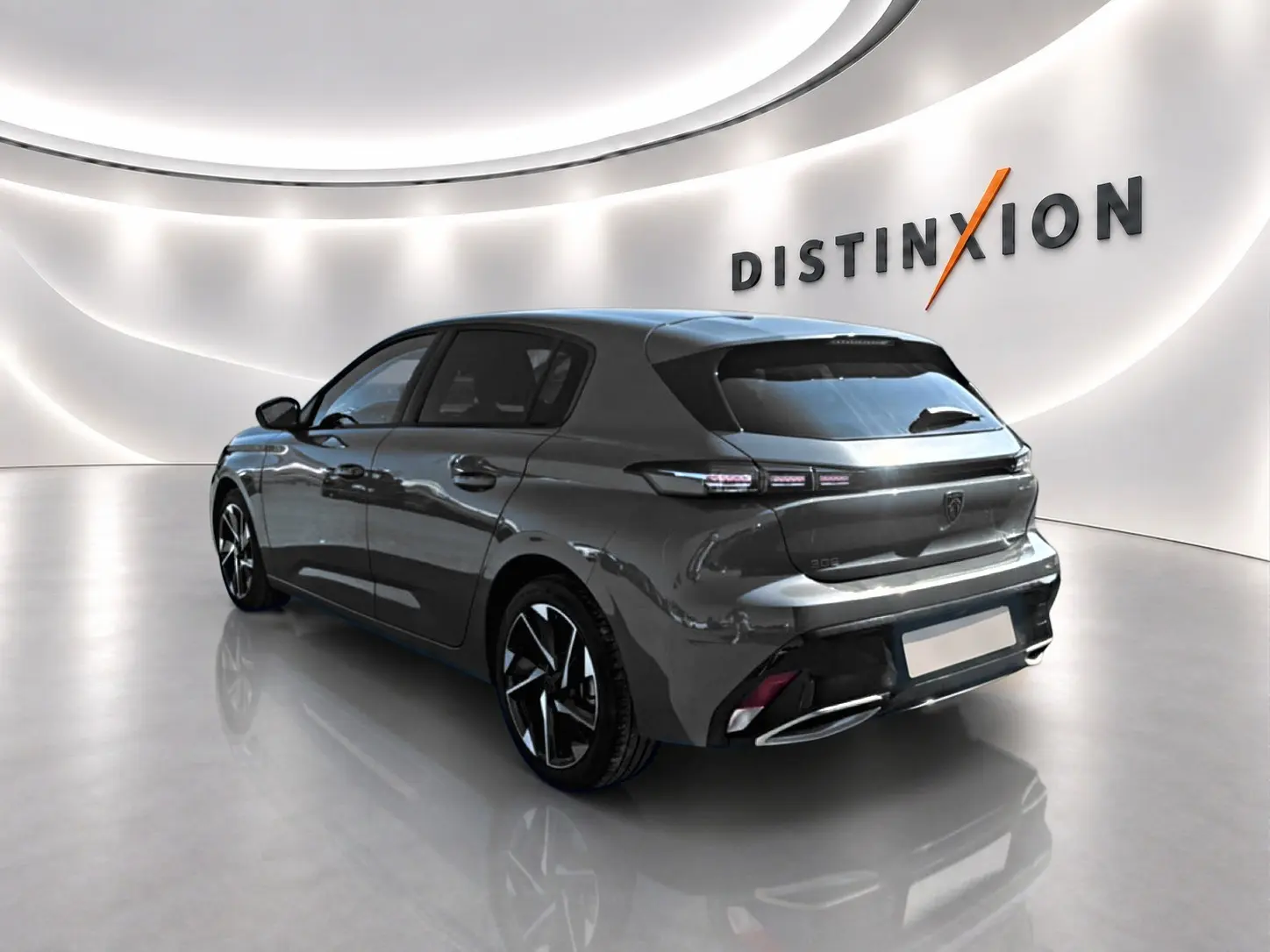 Peugeot 308 gris 3/4 arrière droit dans un showroom lumineux avec jantes alu et feux LED distinctifs.