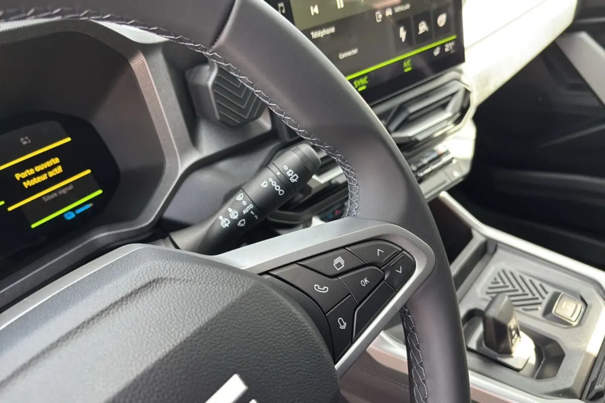 Gros plan sur le volant cuir et le tableau de bord digital du Dacia Bigster Hybrid 155, avec écran tactile et commandes au volant.