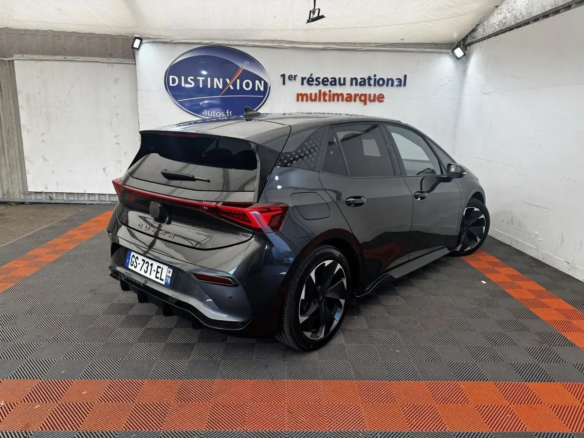 Vue 3/4 arrière droite d'une CUPRA Born gris foncé avec jantes noires et feux arrière LED distinctifs.