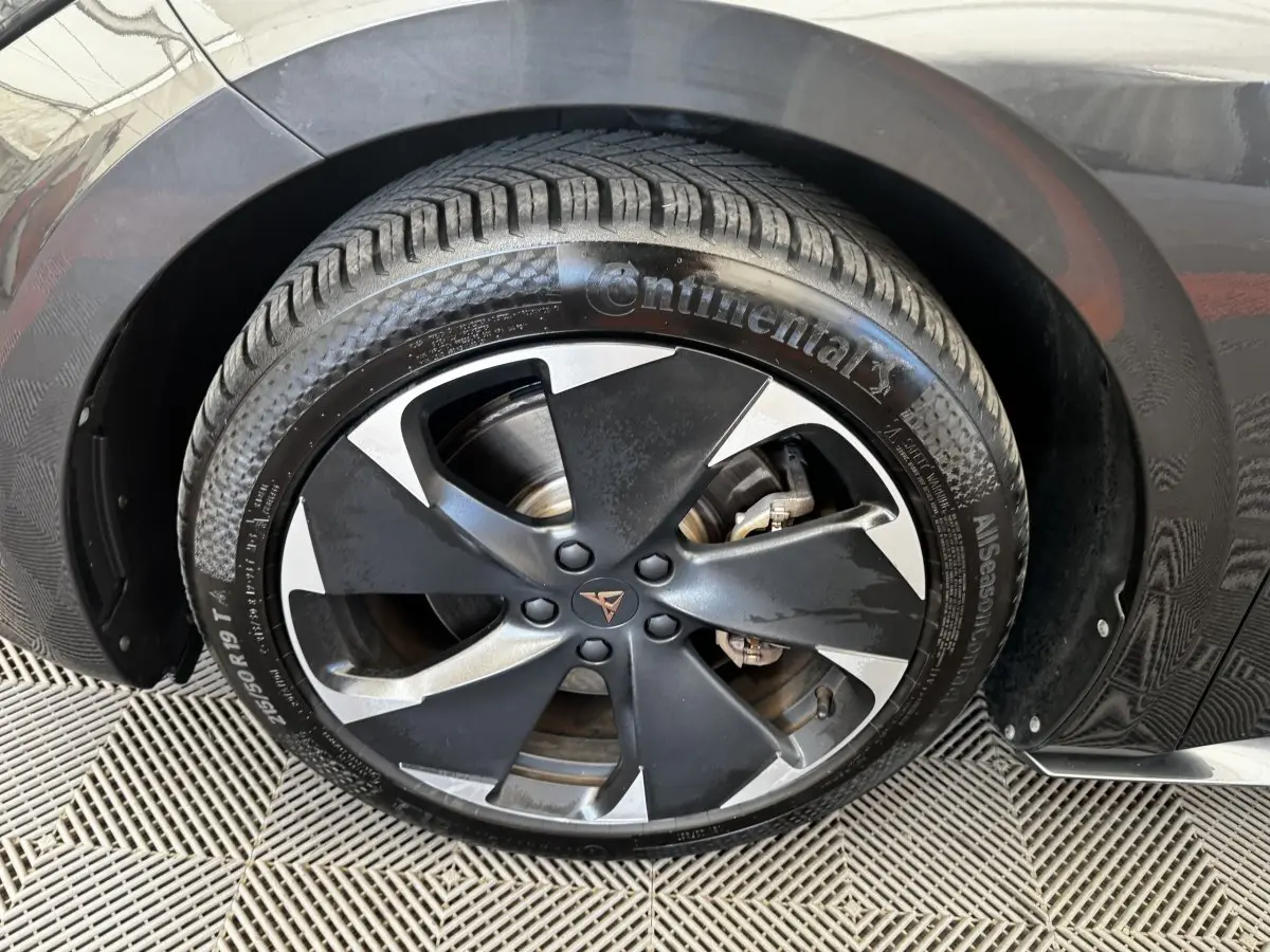Gros plan sur la roue avant droite d'une CUPRA BORN gris foncé avec jante noire et argentée au design moderne.