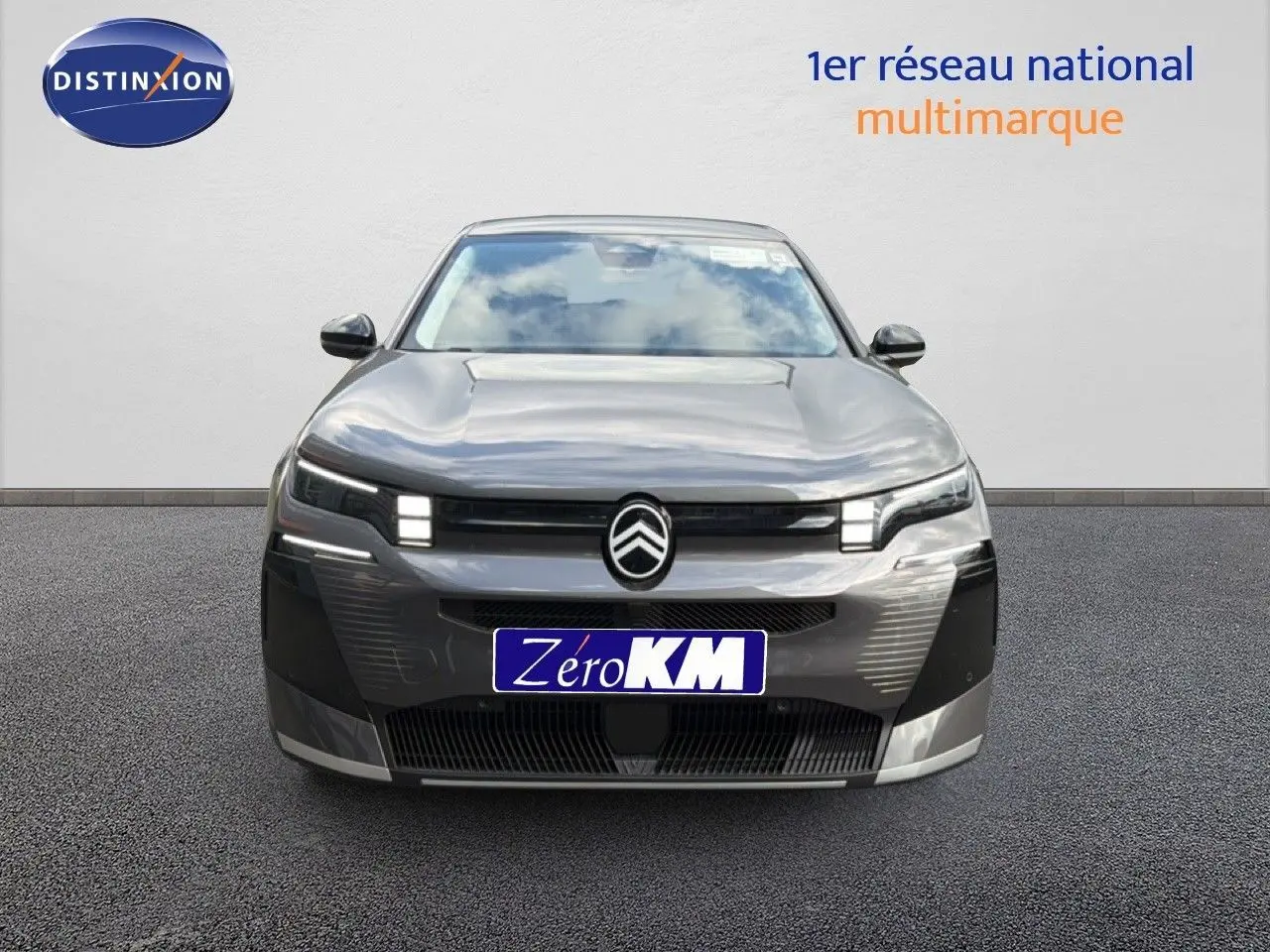 Vue avant d'une Citroën C5 Aircross Hybrid gris platinium métal avec calandre distinctive et phares LED allumés.