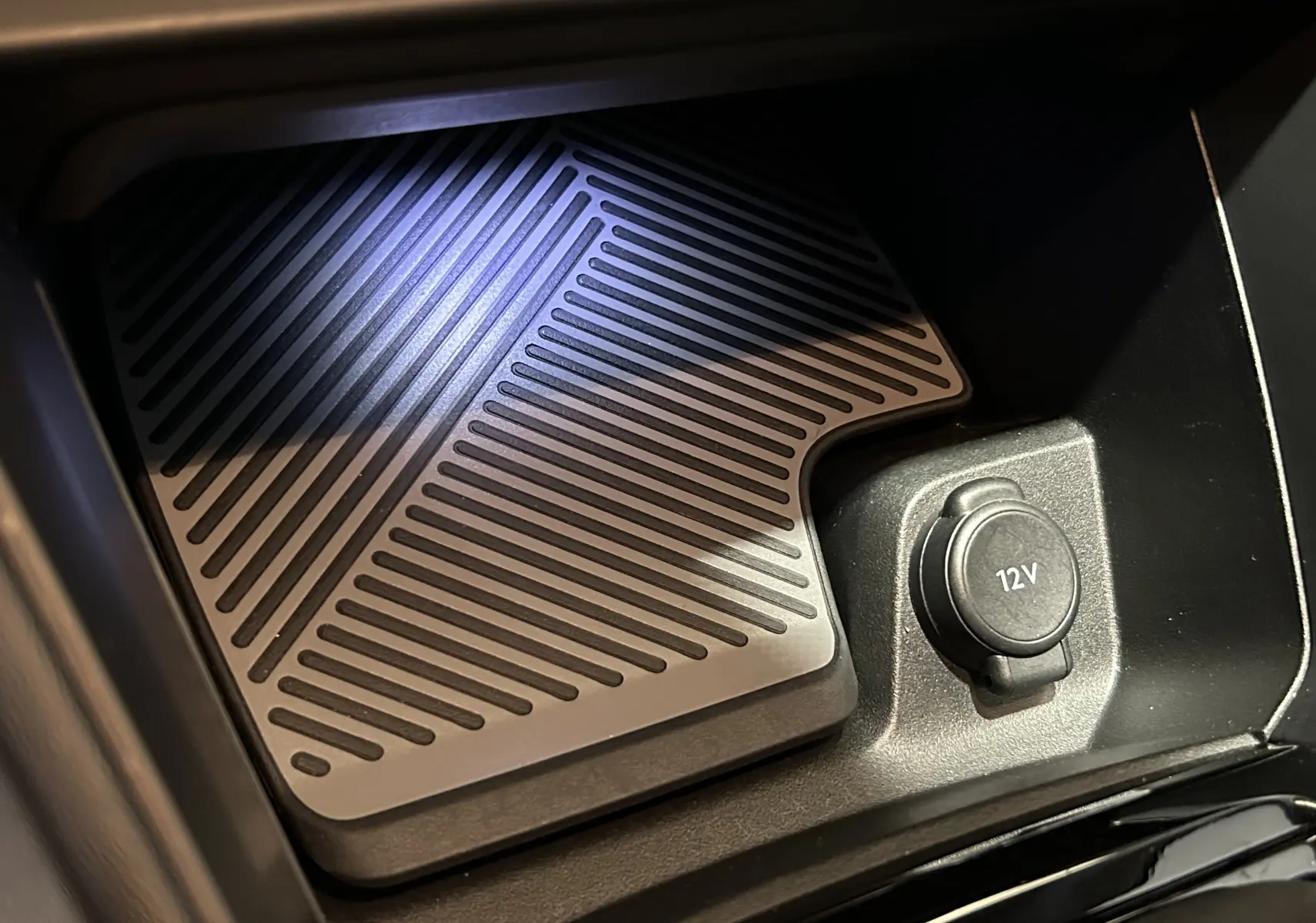 Prise 12V et plateau antidérapant dans le compartiment central d'une Citroën C4 PureTech 100 Feel orange 2021.