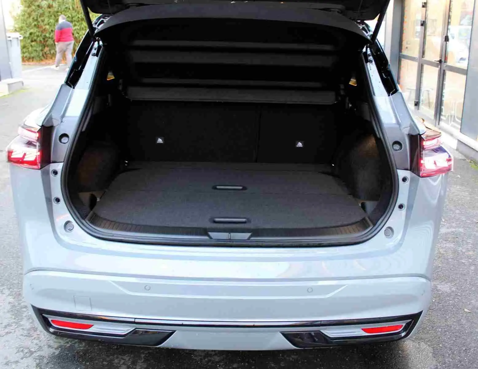 Vue intérieure centrée sur le volant Nissan du Qashqai 2025 avec tableau de bord numérique et écran tactile de navigation.