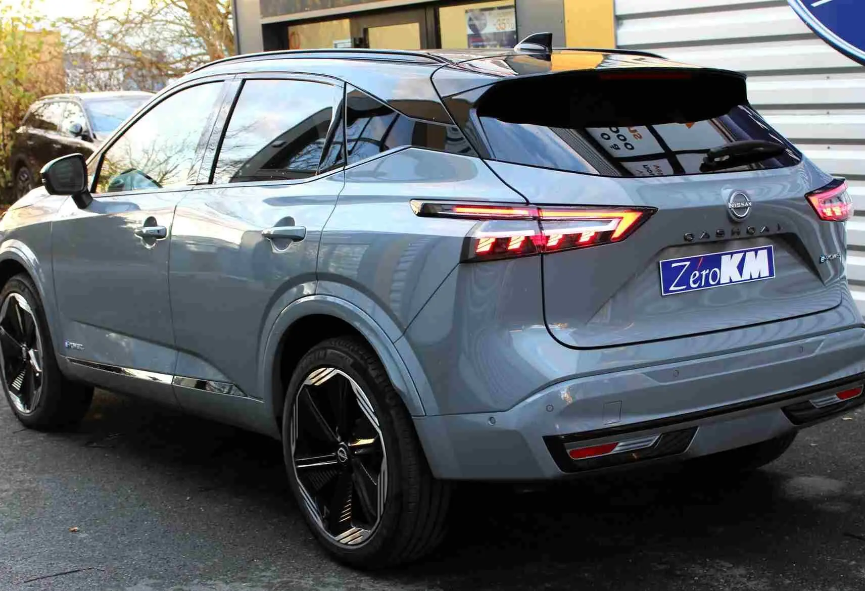 Vue avant du Nissan Qashqai 2025 gris céramique avec toit noir, mettant en valeur sa calandre noire et ses phares LED fins.