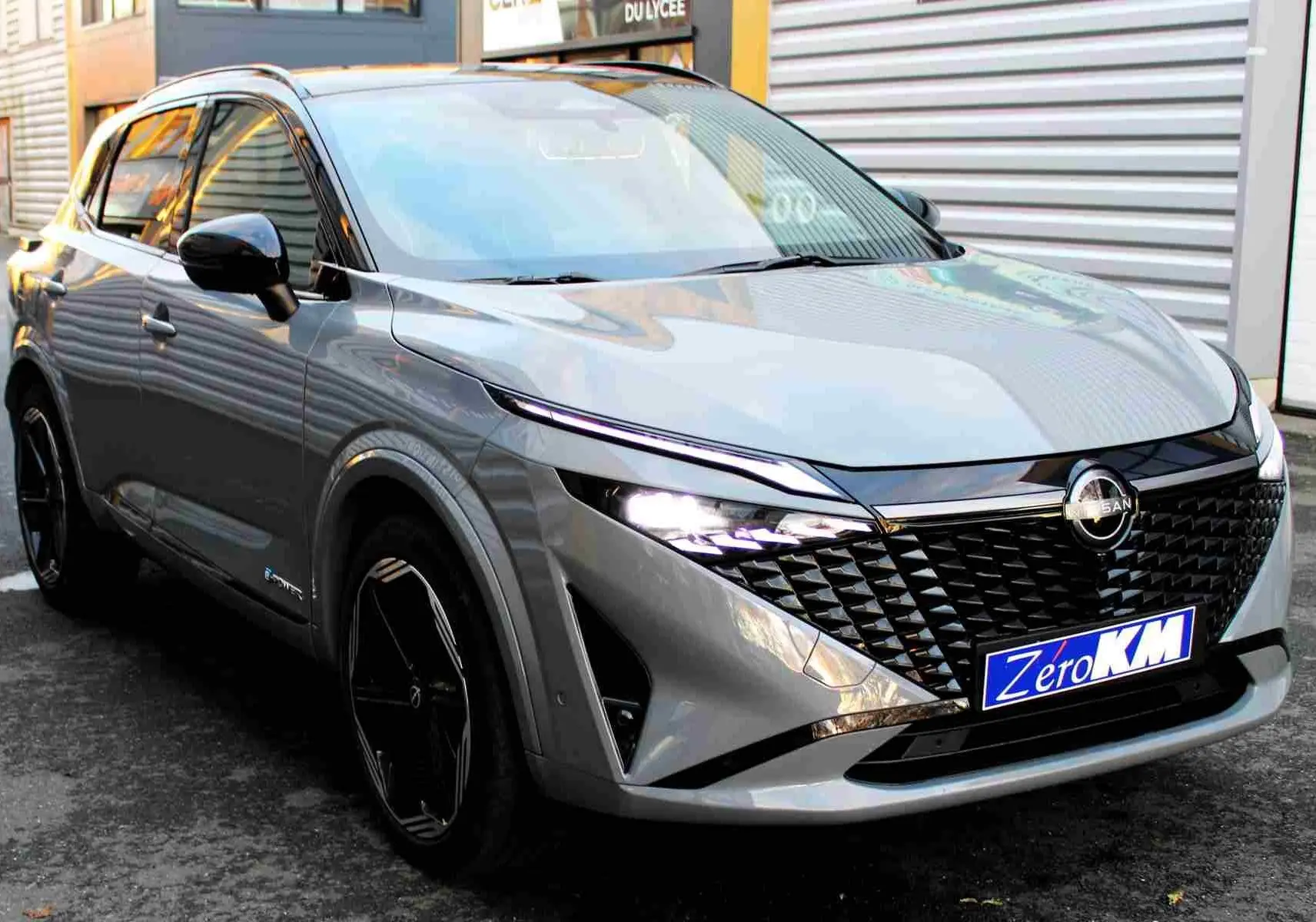 Gros plan sur les commandes au volant du Nissan Qashqai 2025, finition N-Design, avec tableau de bord numérique en arrière-plan.