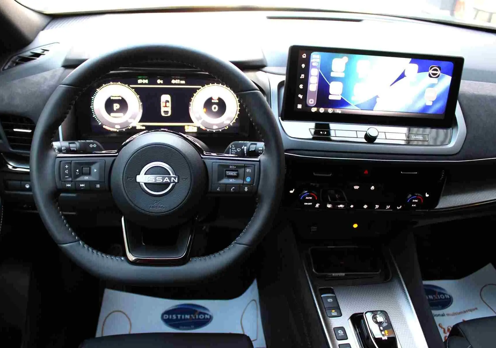 Détail du chargeur sans fil et bouton start/stop dans l'habitacle du Nissan Qashqai 2025 gris céramique.