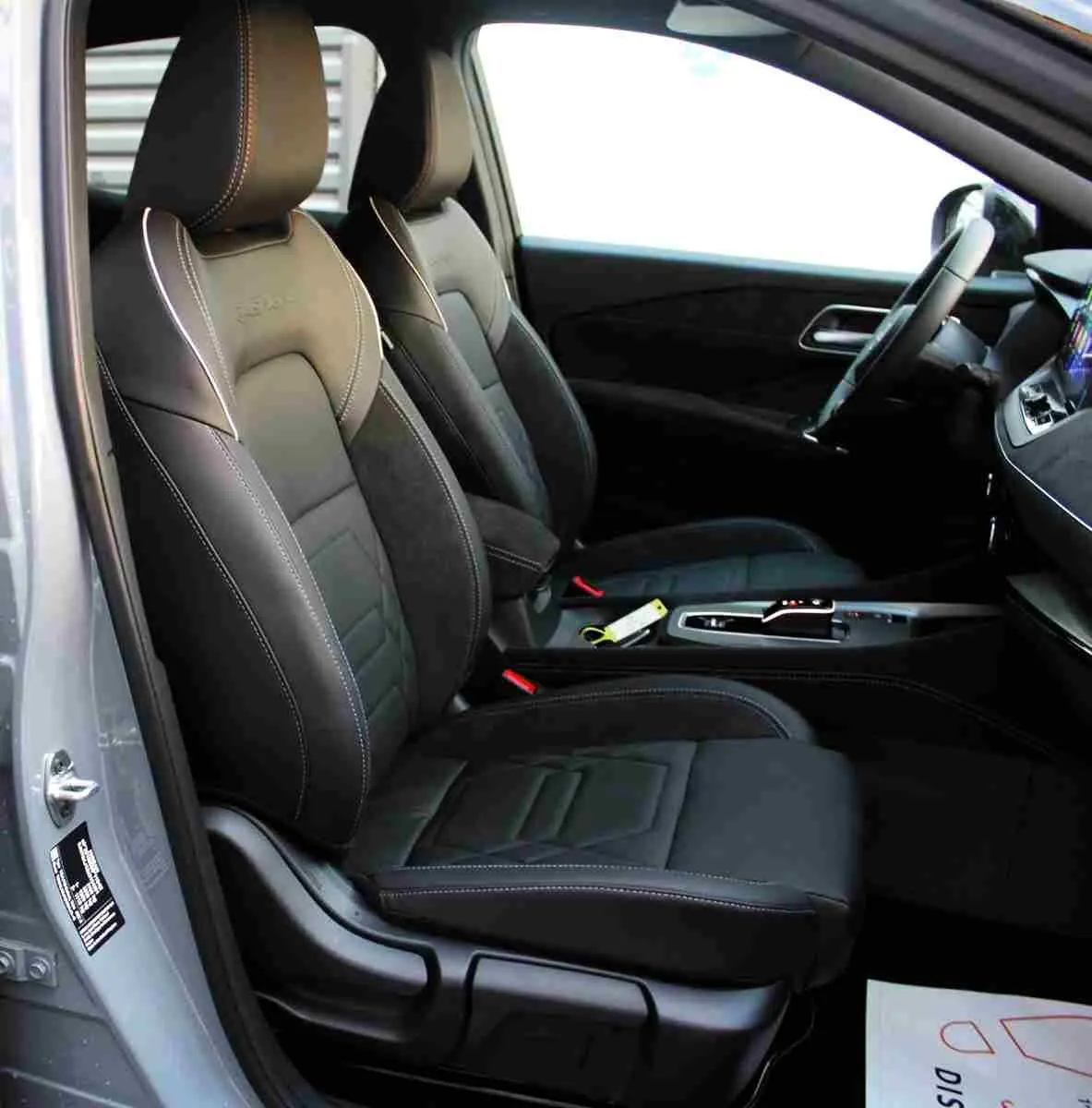 Vue 3/4 arrière droite du Nissan Qashqai 2025 gris céramique avec toit noir et jantes noires distinctives.