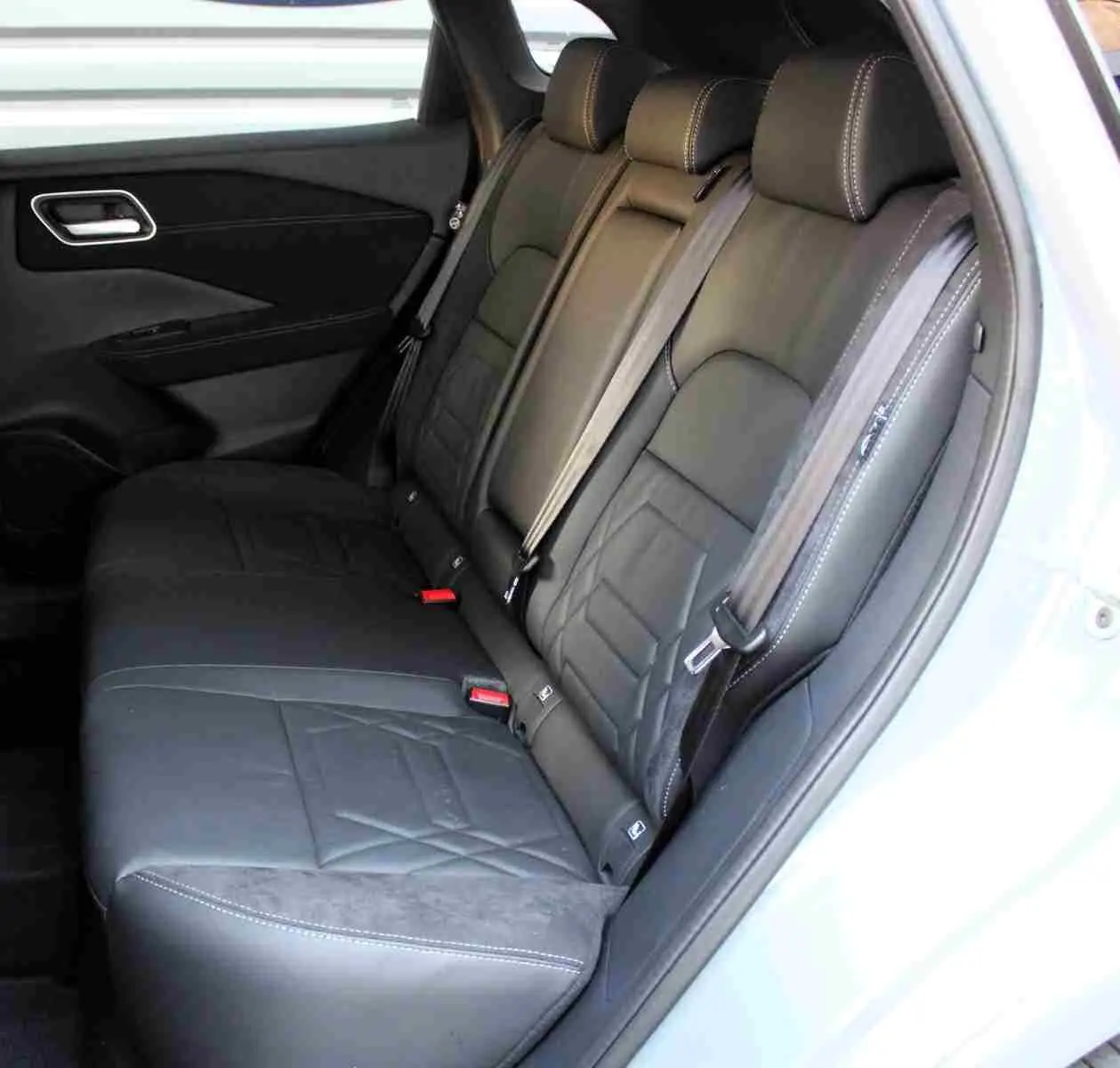 Nissan Qashqai 2025 gris céramique avec toit noir, vue 3/4 arrière côté gauche, roues noires distinctives.